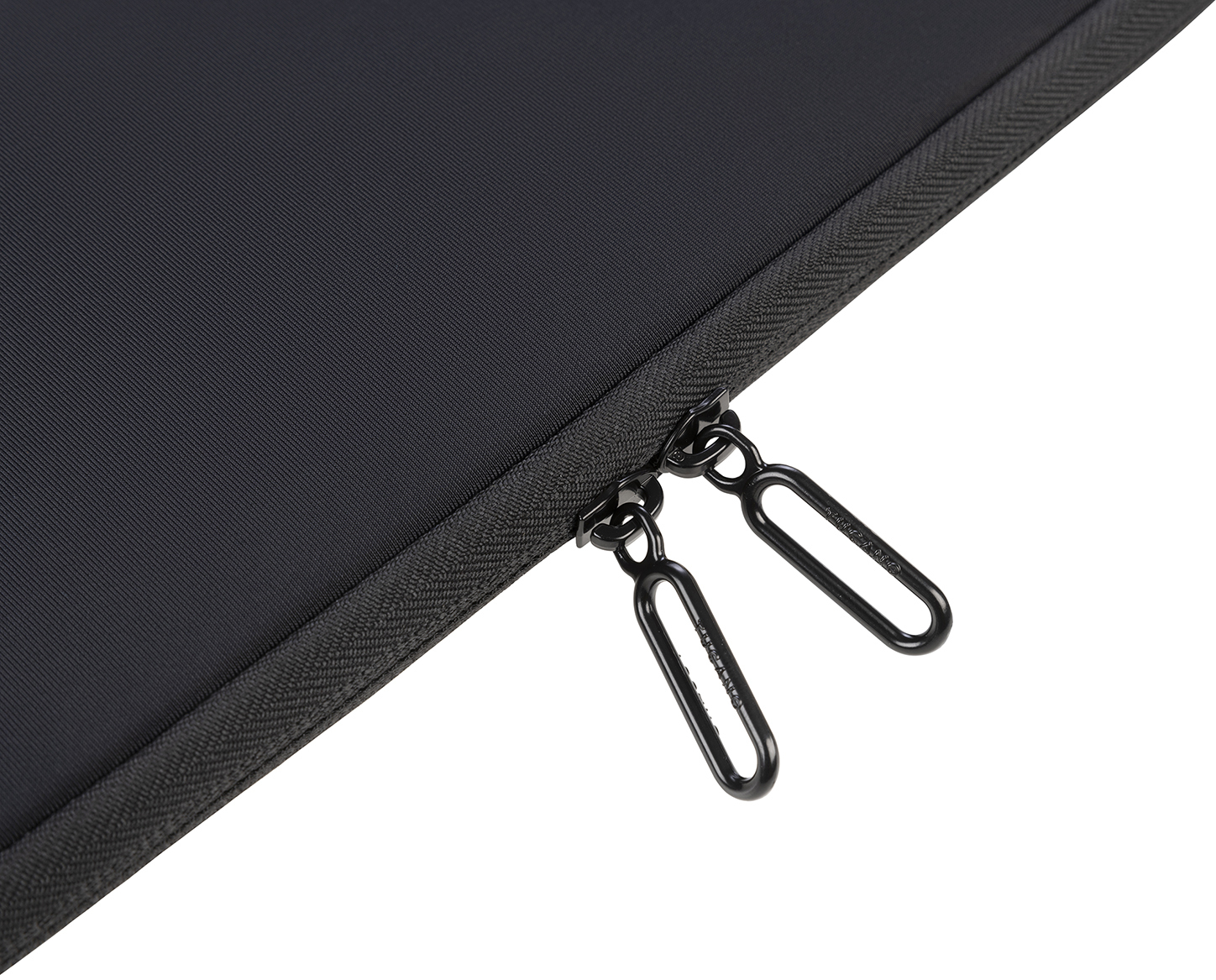 Nahaufnahme von schwarzem Stoff mit Reißverschluss. Die Reißverschlusszipper sind oval und schwarz.