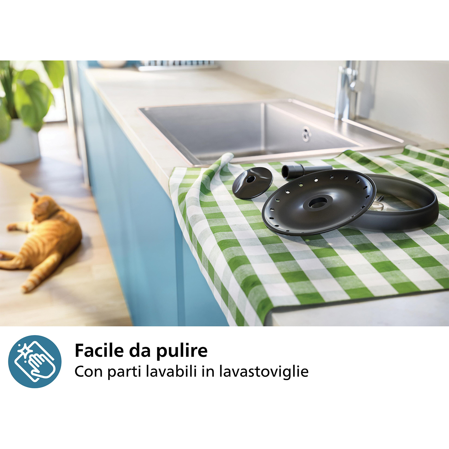 Scena di cucina con un gatto e oggetti per lavare i piatti su un piano di lavoro.