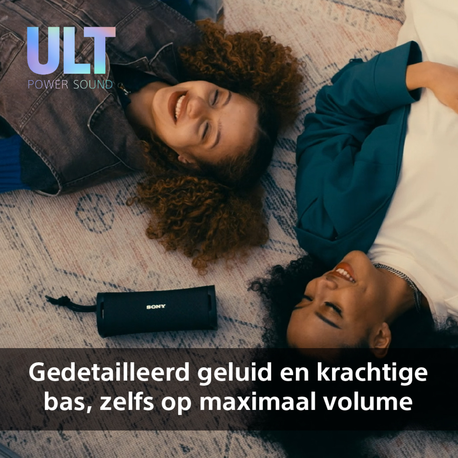 Twee vrouwen liggen, met een zwarte Sony-luidspreker op een kleed. Tekst: Gedetailleerd geluid.