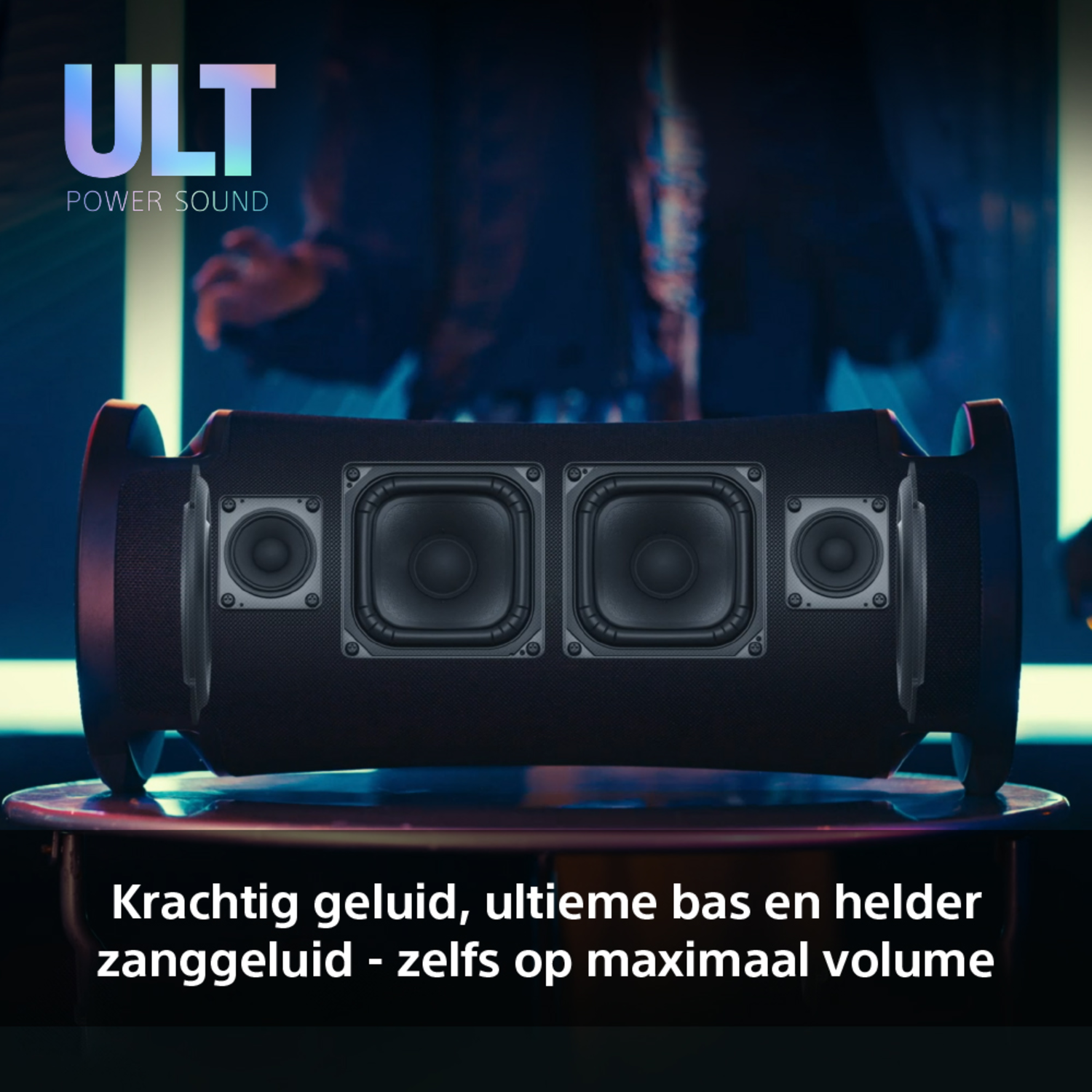 Black speaker with text, on a table. Dark background with text.