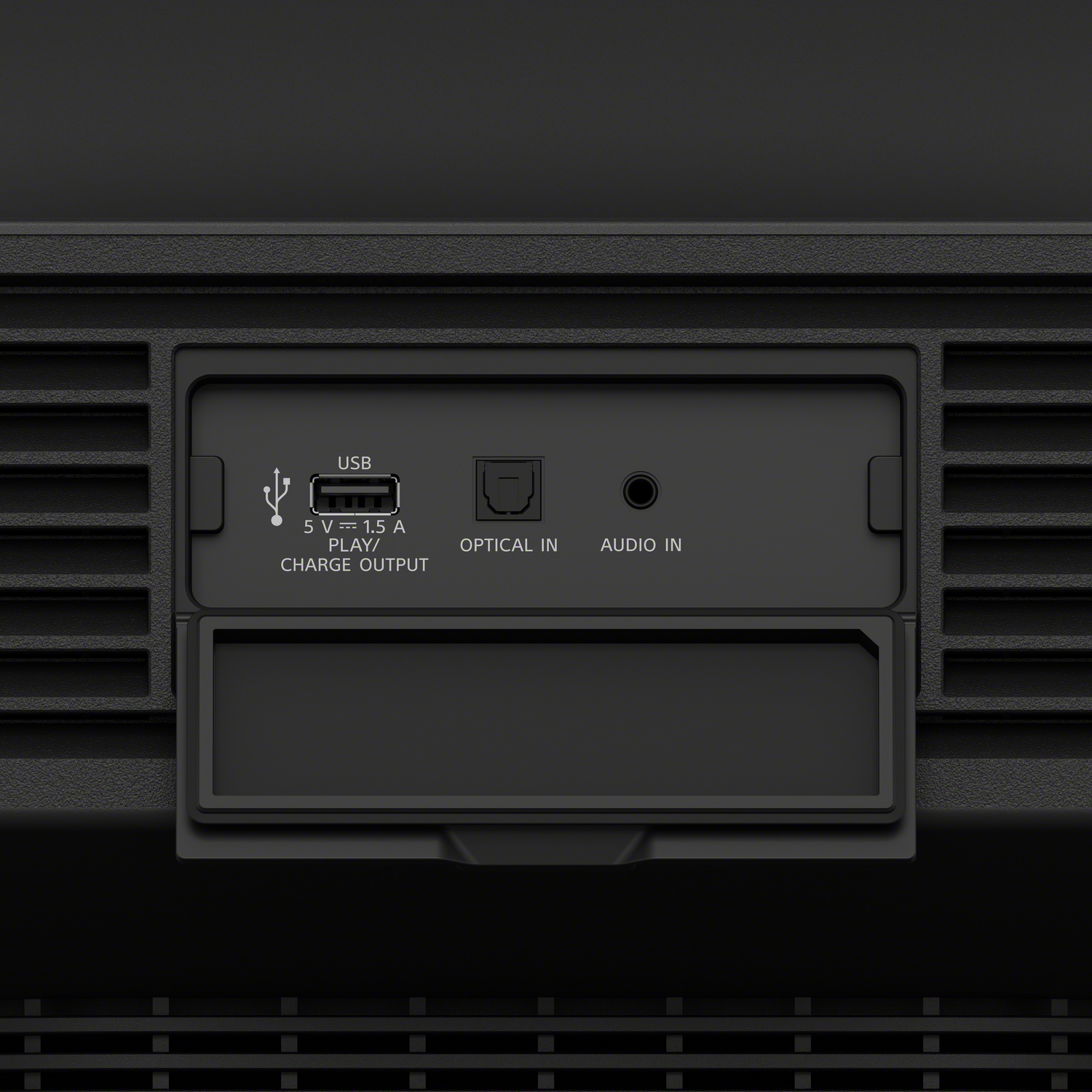 A black panel with a USB, optical, and audio input. It has a small open cover.
