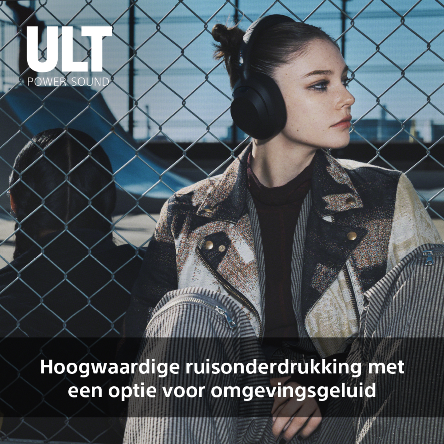 Woman wearing headphones, looking to the right, with a fence in the background.