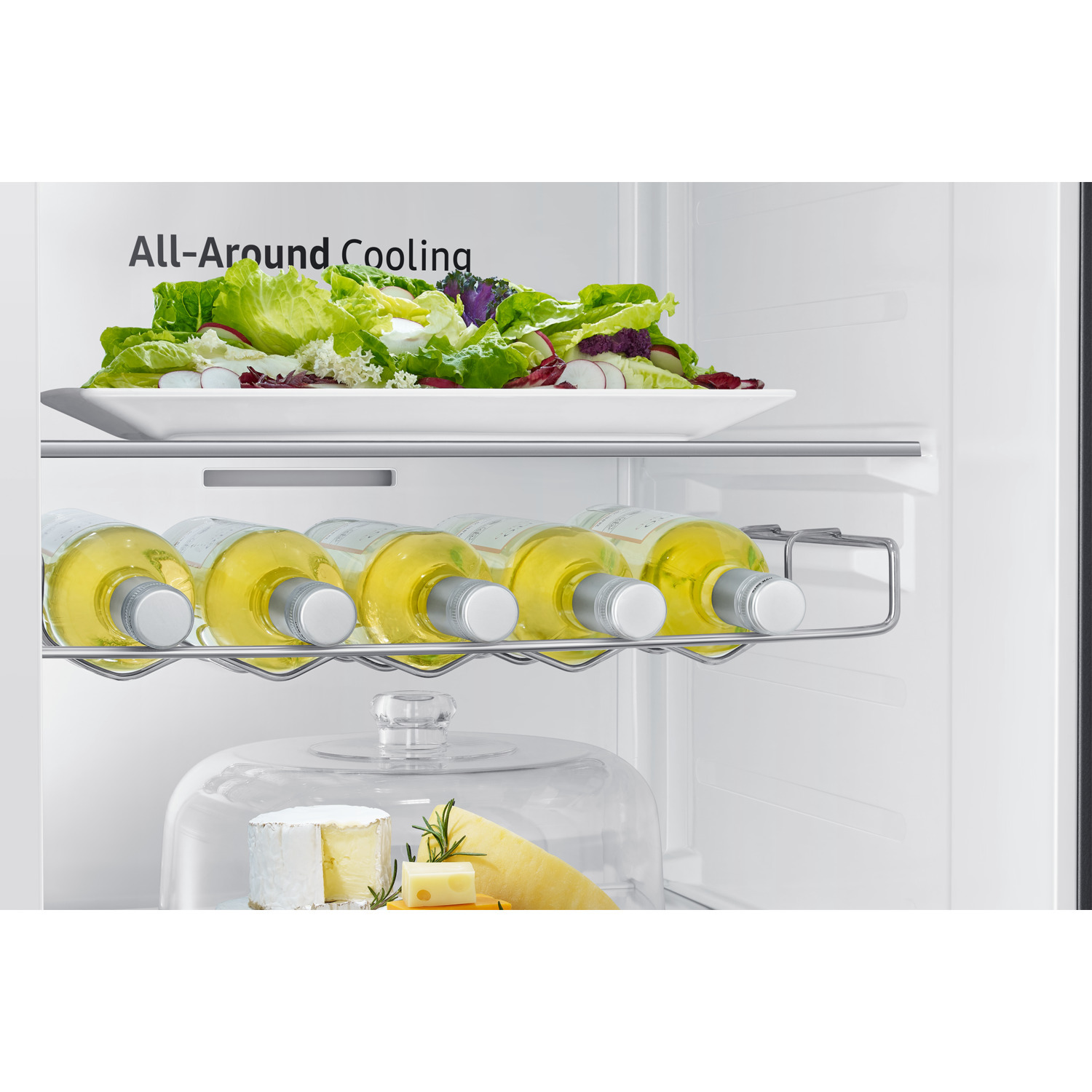 Refrigerator interior with salad, wine bottles, cheese, and glass dome.