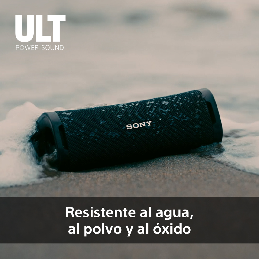 Altavoz negro en la playa, con el texto 'Resistente al agua, al polvo y al óxido'.