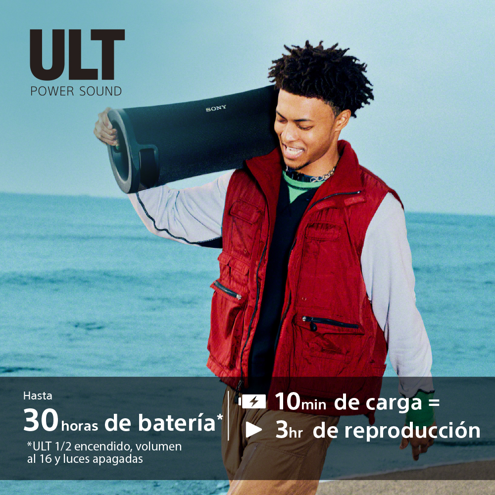 Hombre sosteniendo un altavoz negro en el hombro, fondo de playa.