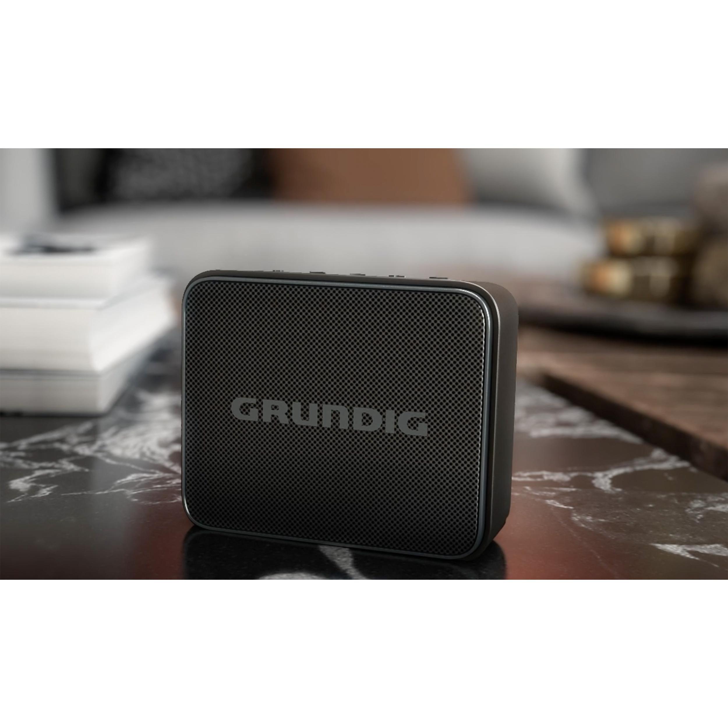 Ein schwarzer Grundig-Lautsprecher auf einem Marmortisch. Der Hintergrund ist unscharf.