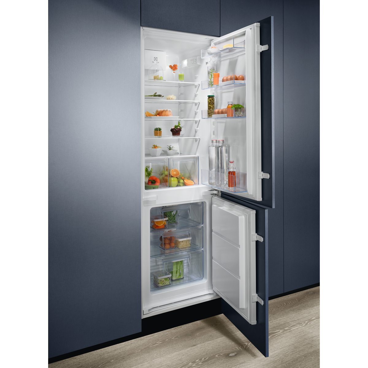 Refrigerador con la puerta abierta, lleno de comida.