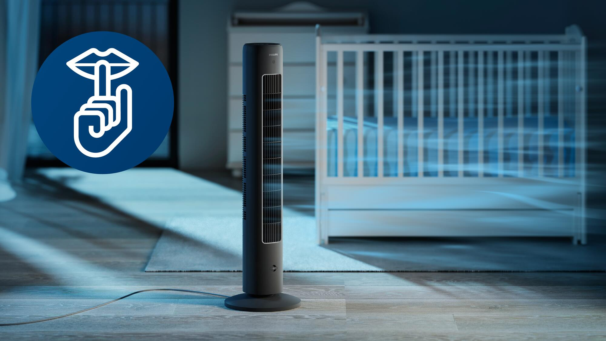 Un ventilador negro en una habitación con una cuna. Un gesto de mano está a la izquierda.