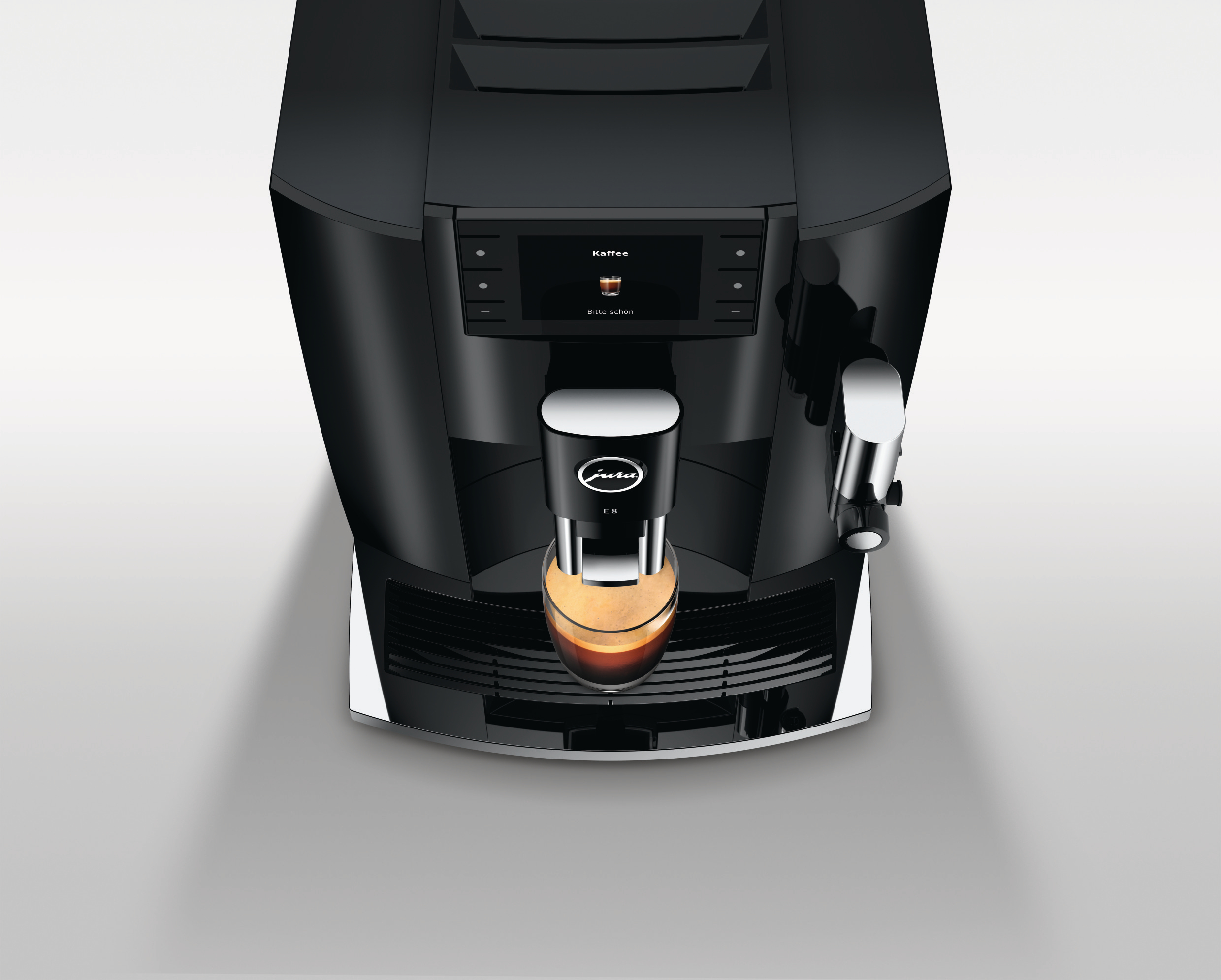 Espressomaschine. Schwarz mit Digitalanzeige, Kaffee in ein Glas ausschenkend, auf weißem Hintergrund.