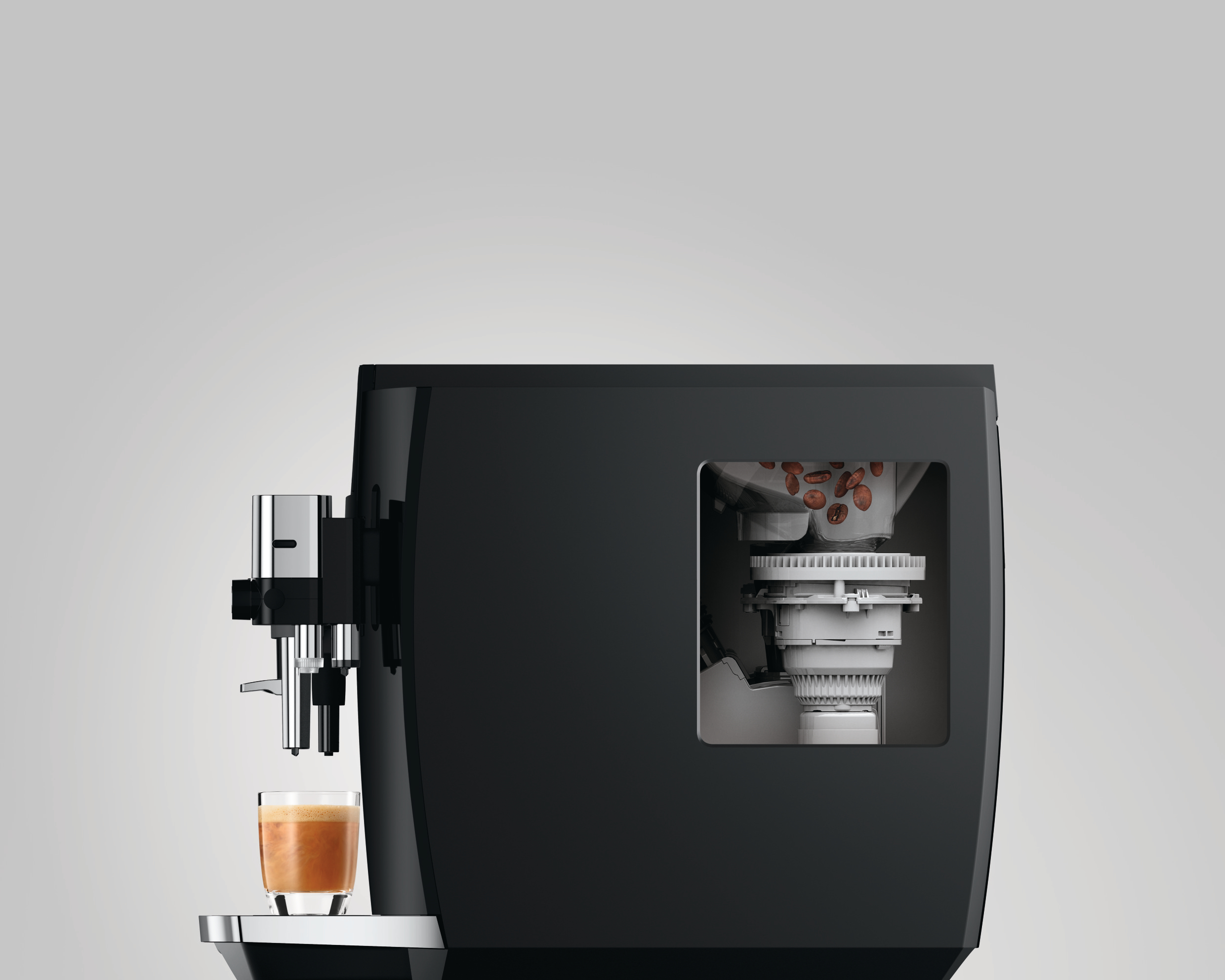 Eine schwarze Jura Kaffeemaschine, die den Bohnenbehälter und den in ein Glas abgefüllten Kaffee zeigt.