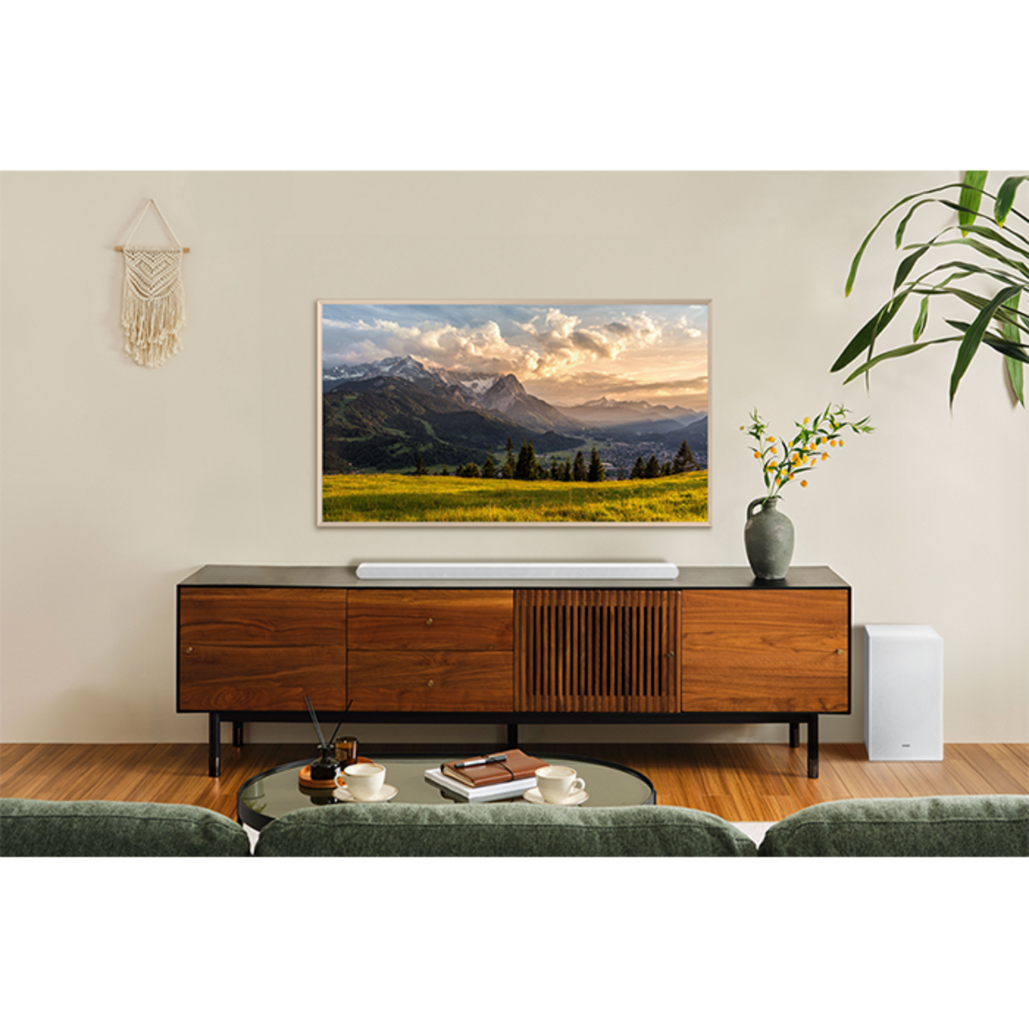 Living room with TV, soundbar, and a white subwoofer. A coffee table and sofa are in front.