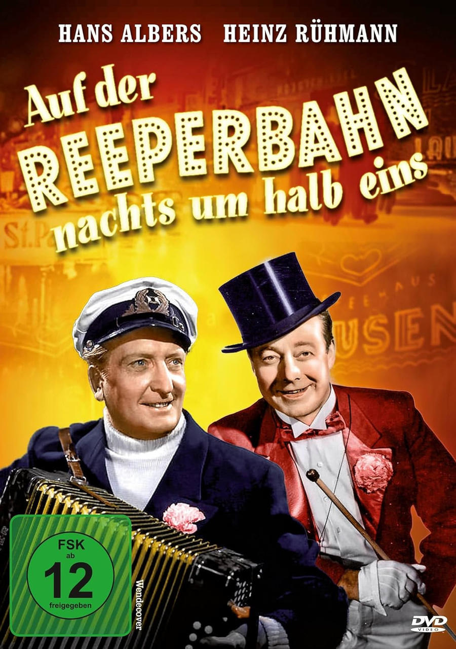 Ein DVD-Cover mit zwei Männern im Anzug, einem grünen FSK 12 Logo und deutschem Text.
