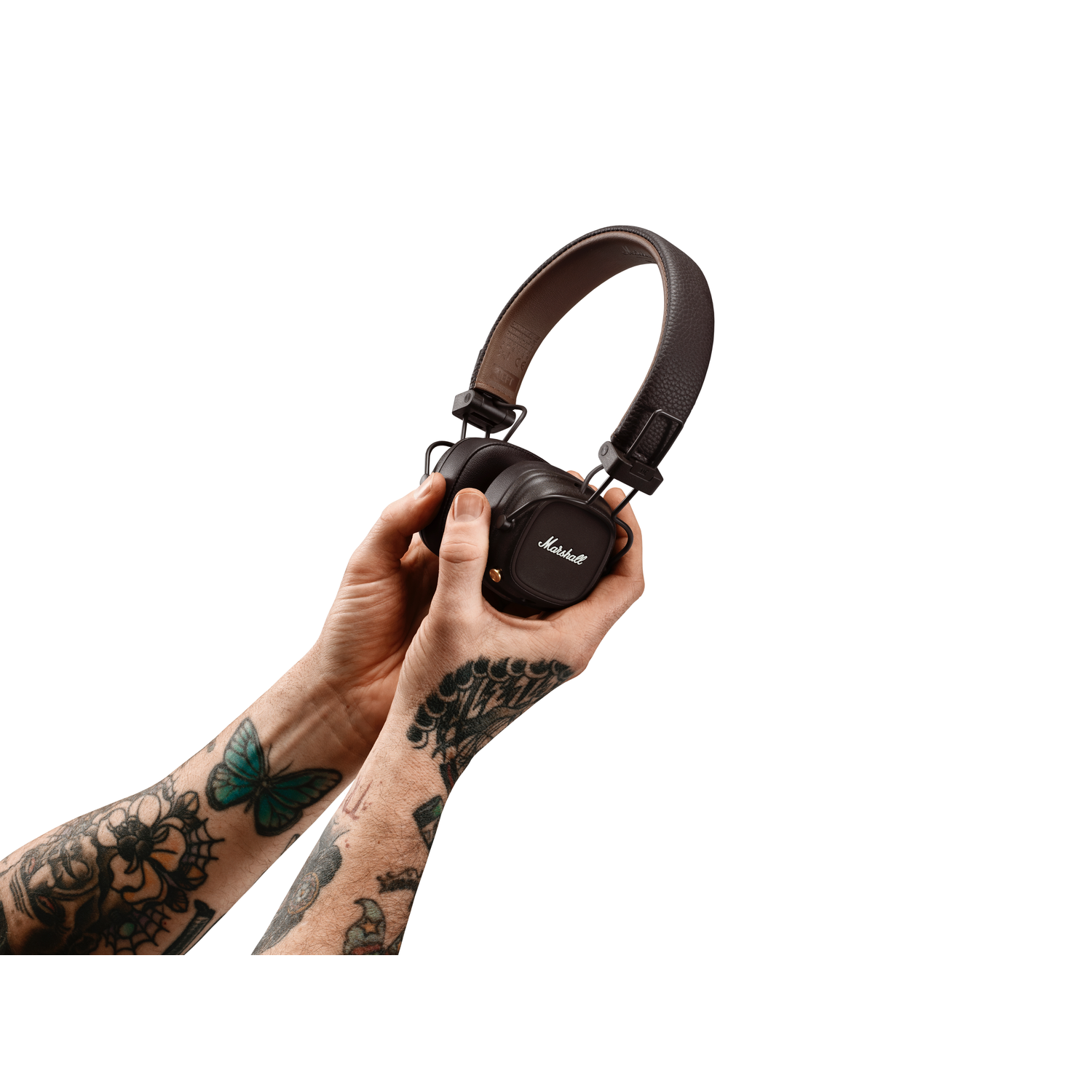 Handen die Marshall koptelefoon vasthouden. De handen zijn getatoeëerd. Witte achtergrond.