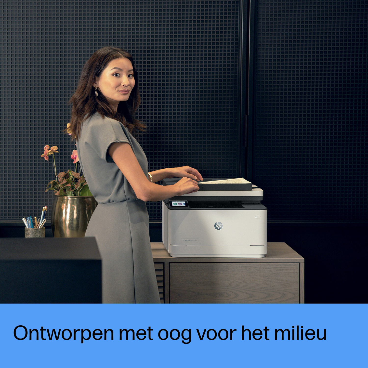 A woman using a white HP printer. The background has a black textured wall and a plant.