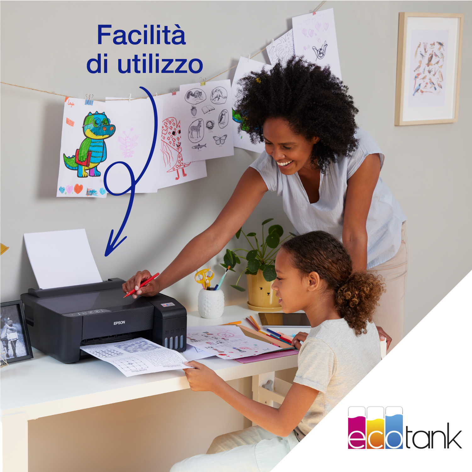 Madre e figlia a una scrivania, che disegnano con una stampante sullo sfondo.