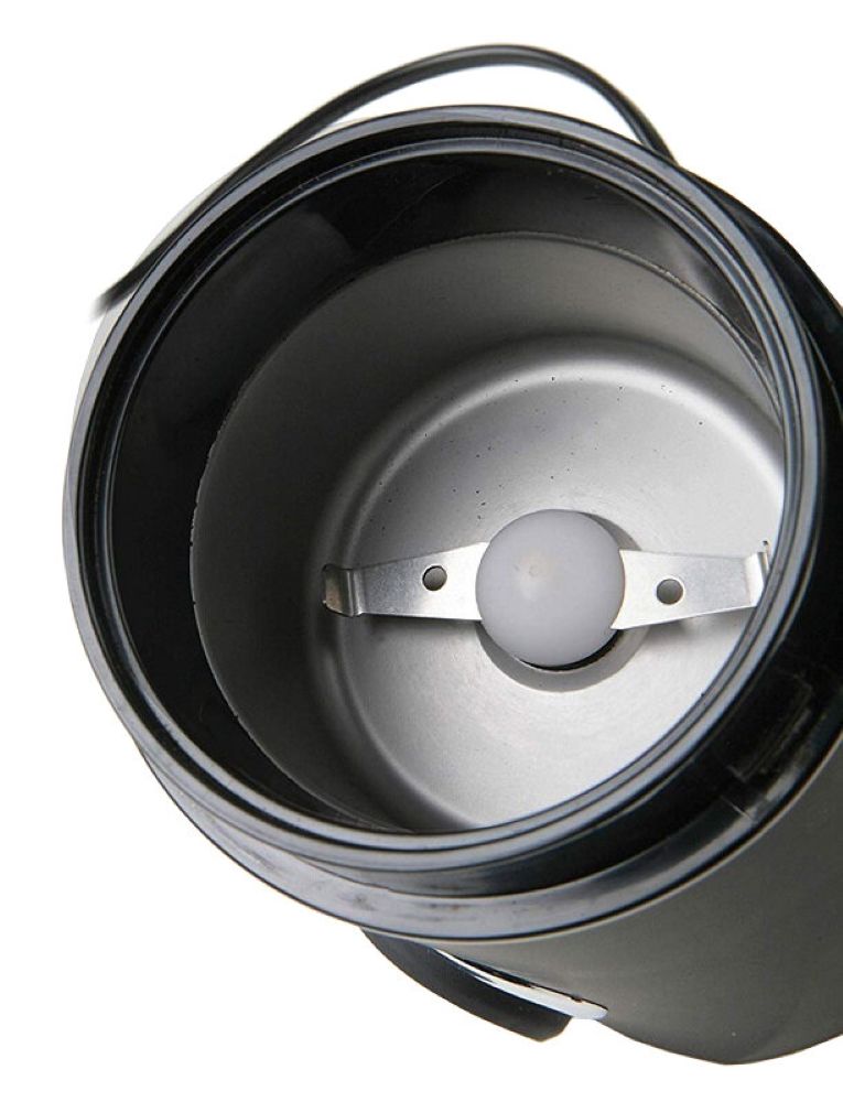 Zbliżenie młynka do kawy z ostrzem w środku i uchwytem.