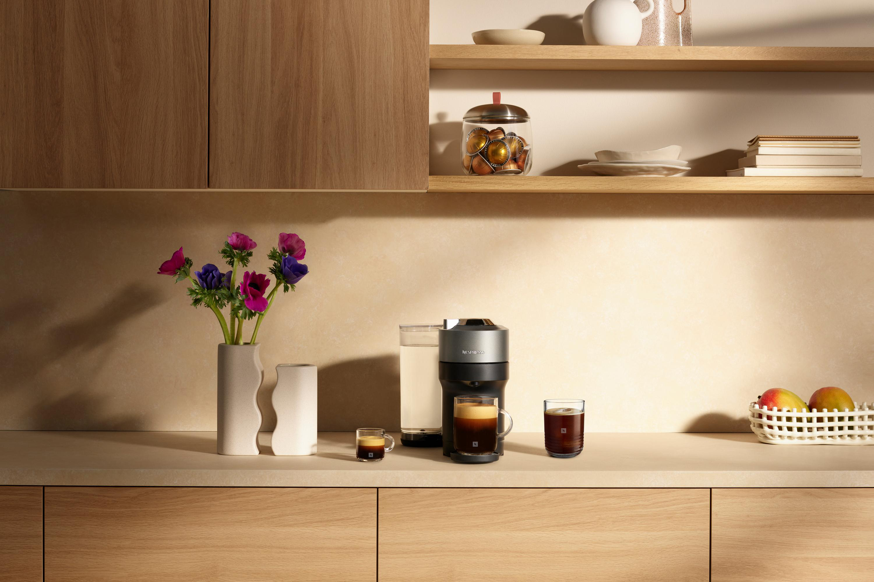 Eine Kaffeemaschine mit Kaffeetassen und einigen Blumen.