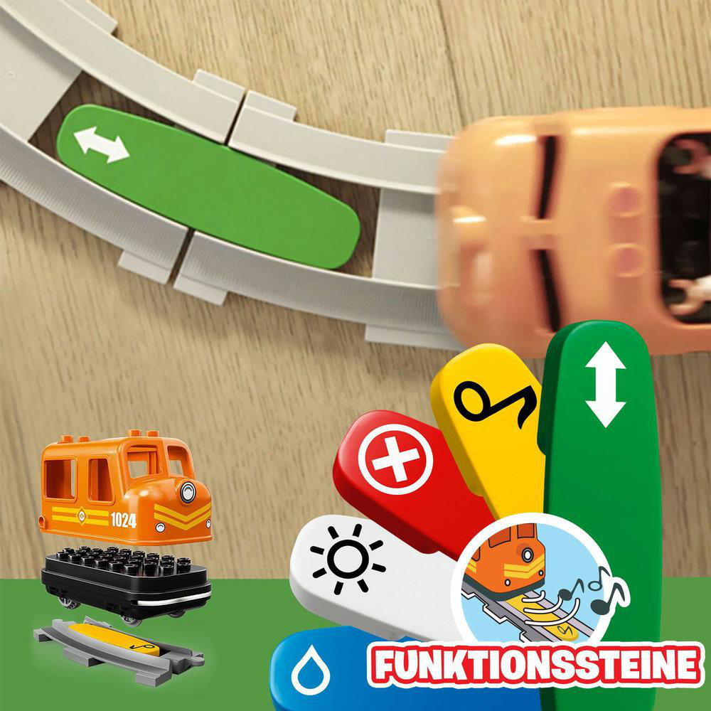 Oranger Spielzeugzug und Schienenteile. Grüne und rote Funktionsblöcke mit Symbolen.