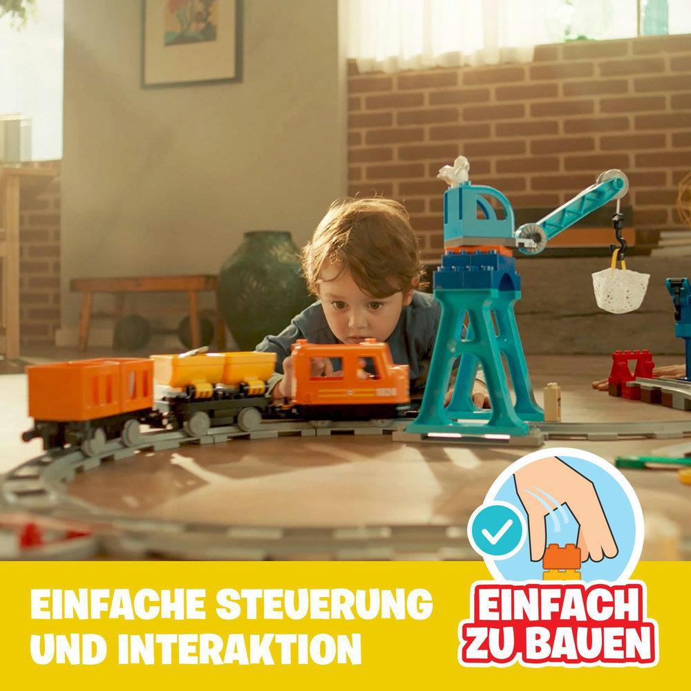 Ein Kind spielt mit einer Spielzeugeisenbahn. Waggons und ein Kran sind im Bild. Text: Einfache Steuerung und Bauen.