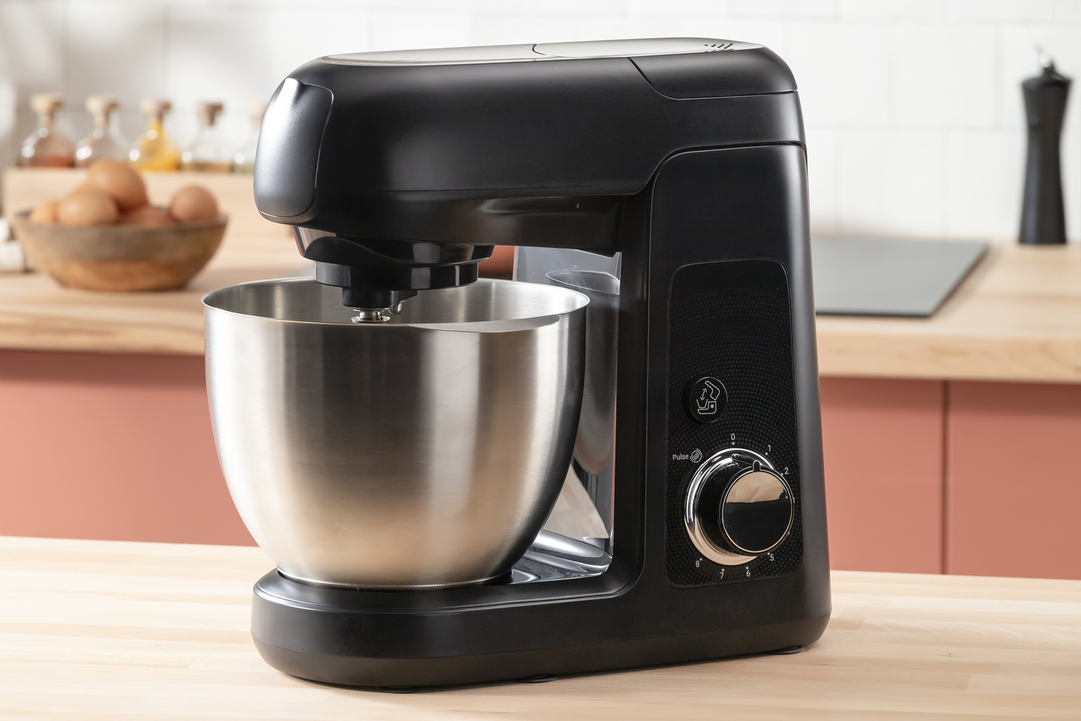 Fekete konyhai mixer fa pulton, tojásokkal és fűszerőrlővel.