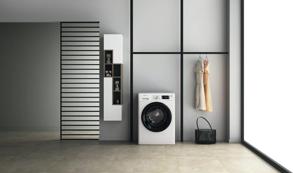 Moderne wasruimte met een wasmachine, kasten en een kledingrek.