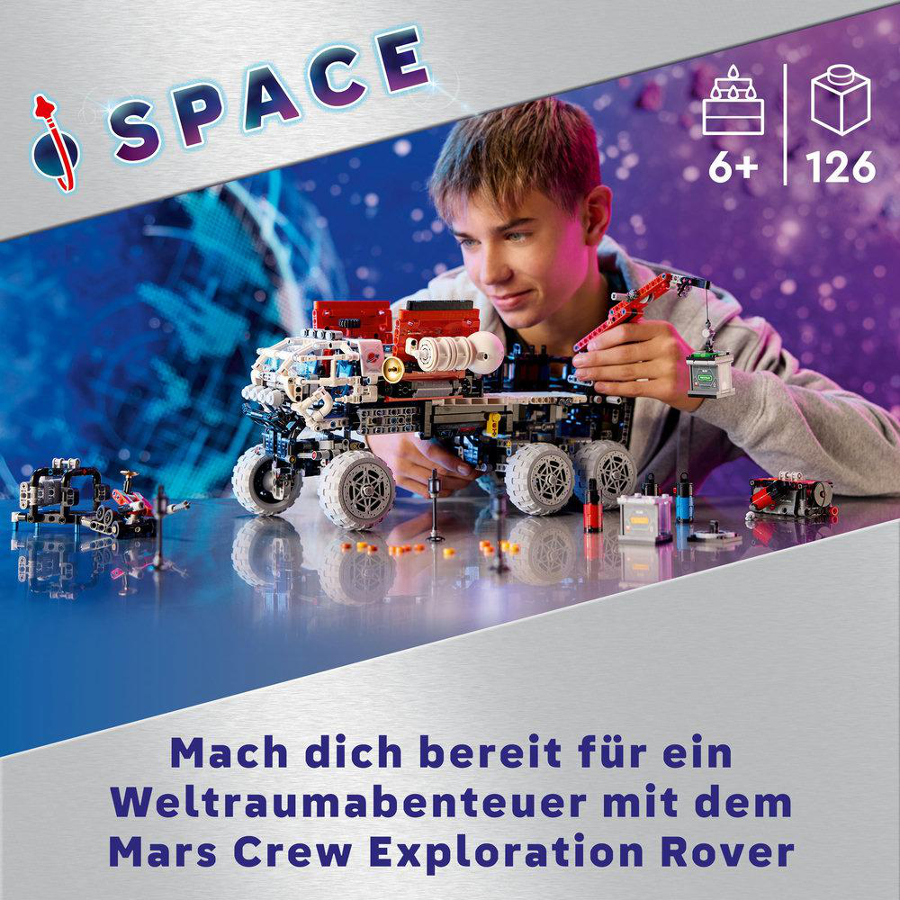 Ein Junge baut einen Lego-Weltraumrover mit anderen Legoteilen auf einer reflektierenden Oberfläche.