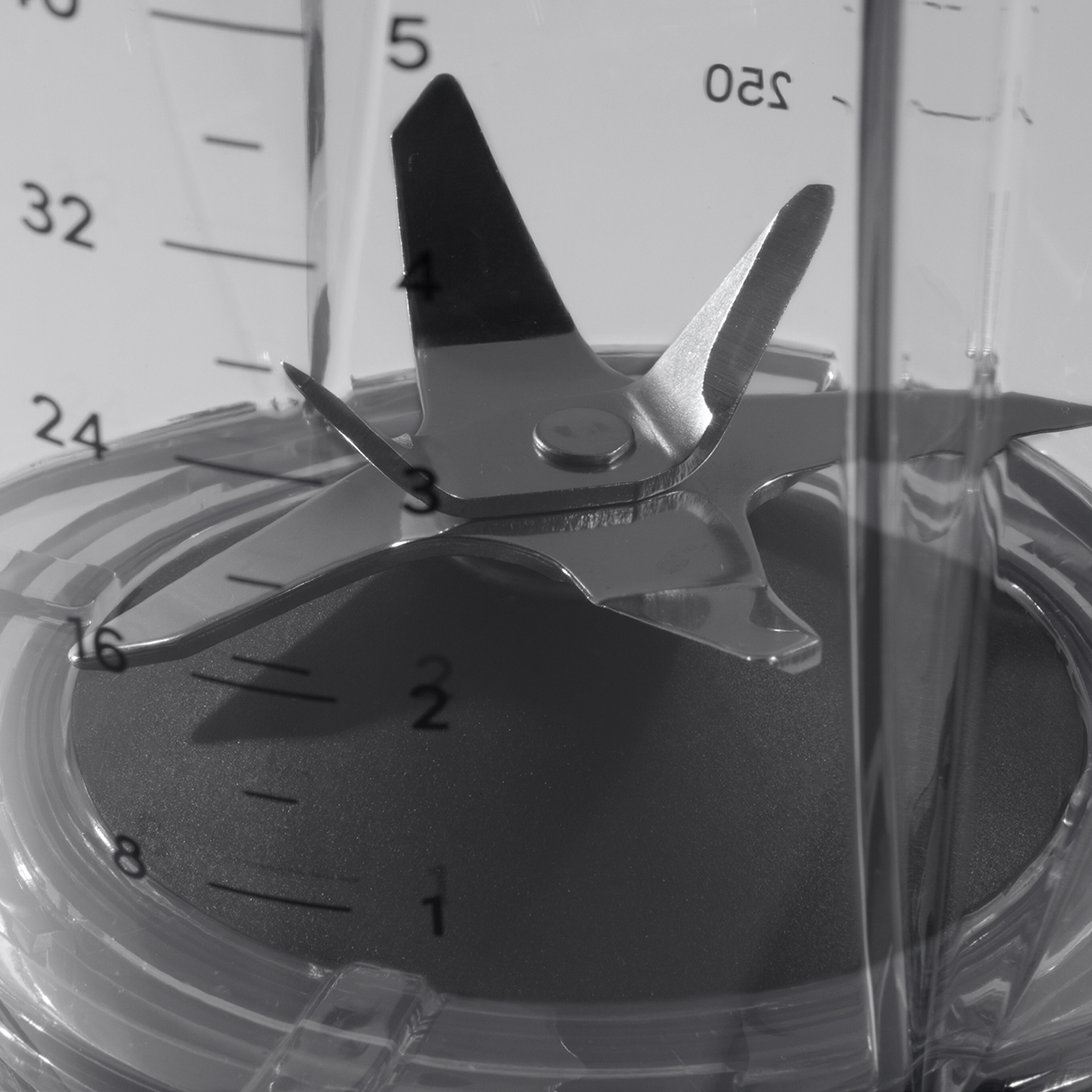 Nahaufnahme der Klingen eines Mixers mit Messmarkierungen auf dem Behälter.