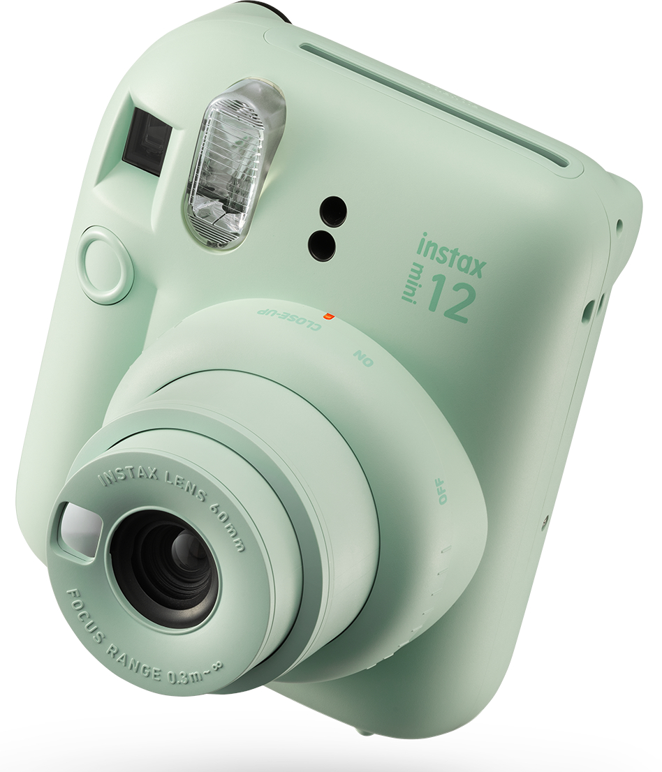 Miętowa kamera Instax Mini 12 z obiektywem, lampą błyskową i różnymi przyciskami, na białym tle.