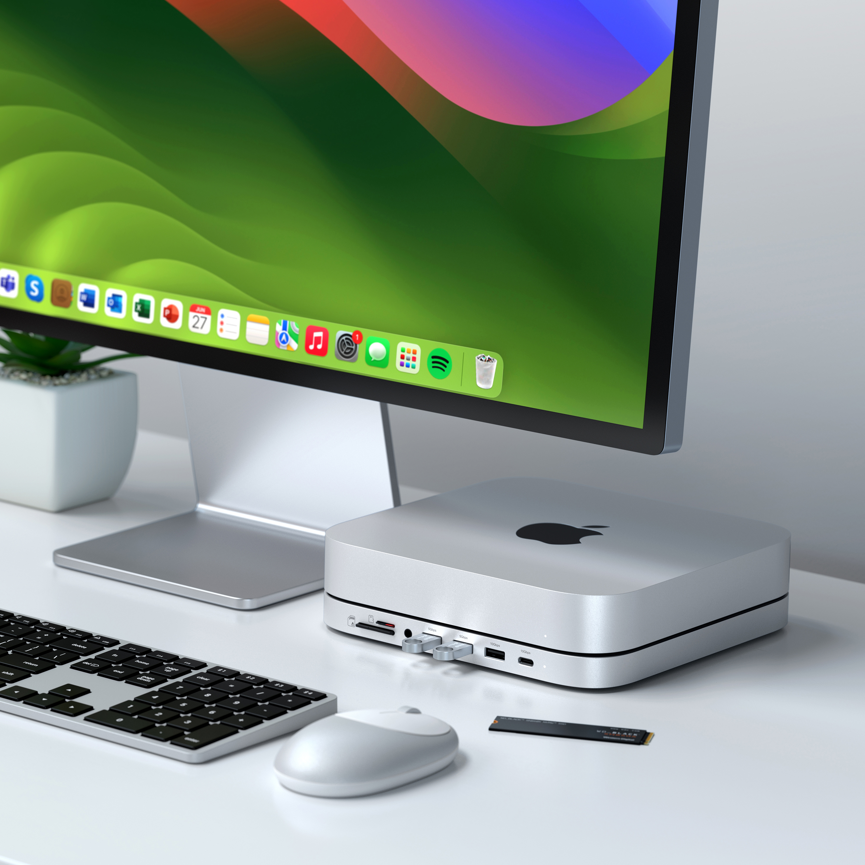 Apple Mac Mini auf einem weißen Schreibtisch, mit Monitor, Tastatur, Maus und externer SSD.