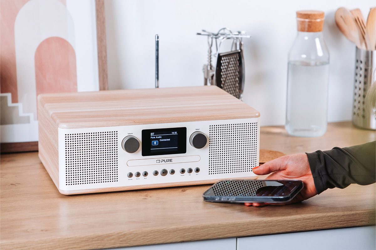 Une radio en bois avec un téléphone sur le comptoir.
