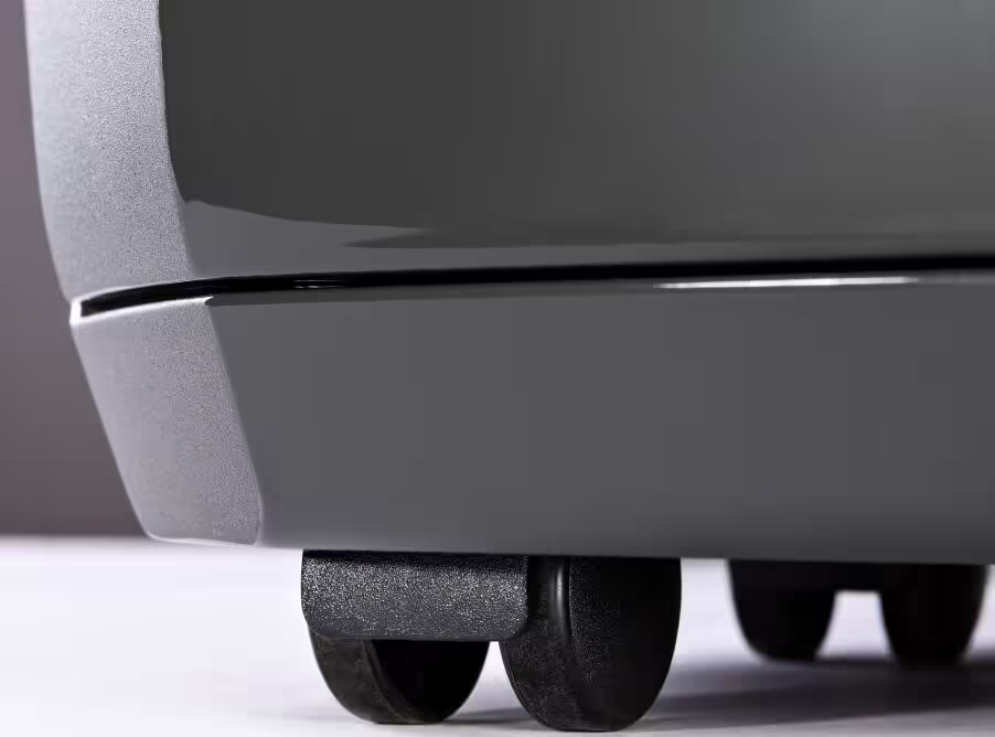 Un primo piano di ruote nere su un elettrodomestico grigio scuro.