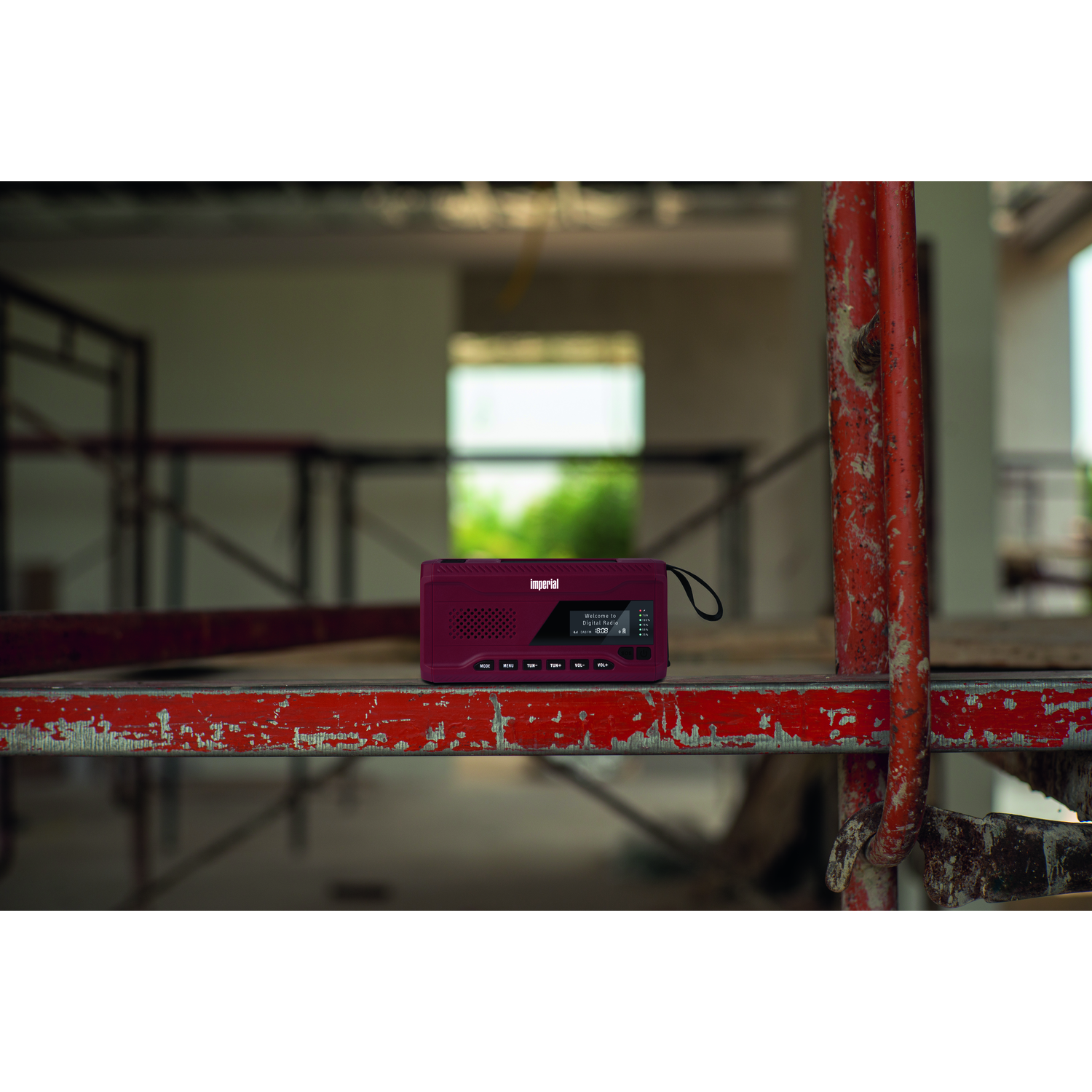 Radio op bouwplaats, met een rood metalen frame.