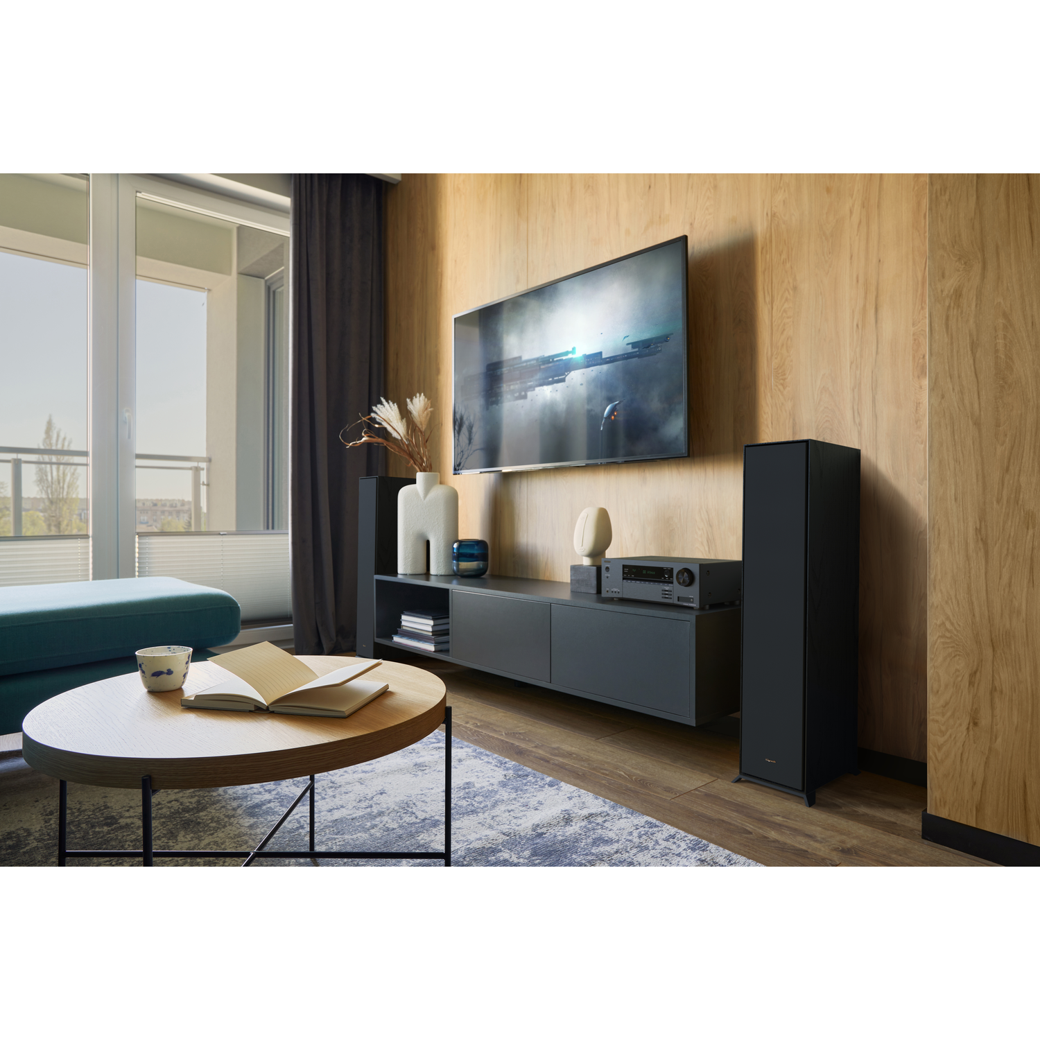 Living room with TV, speakers, and a console table. A coffee table with an open book.
