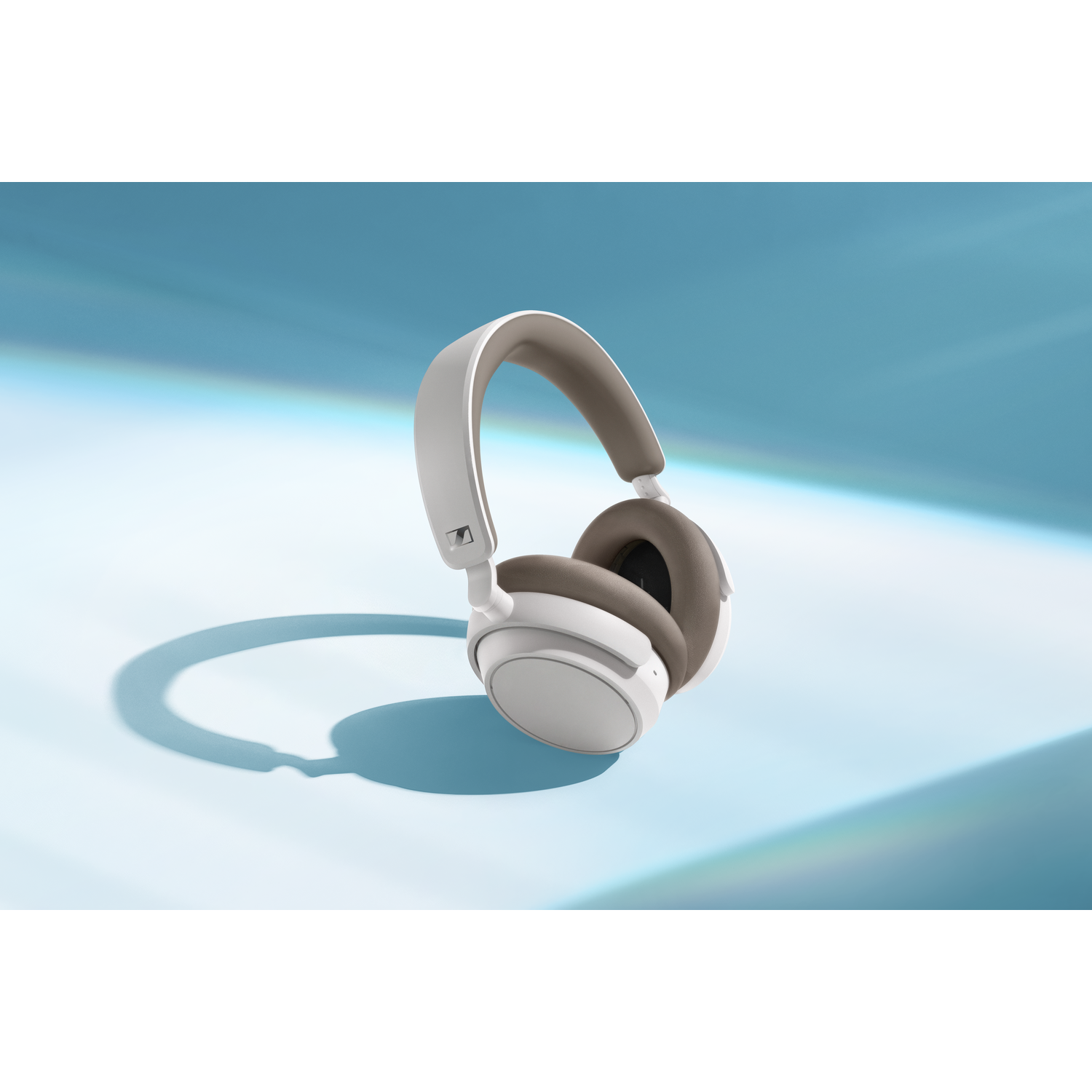 White and brown headphones on a blue and turquoise gradient background.