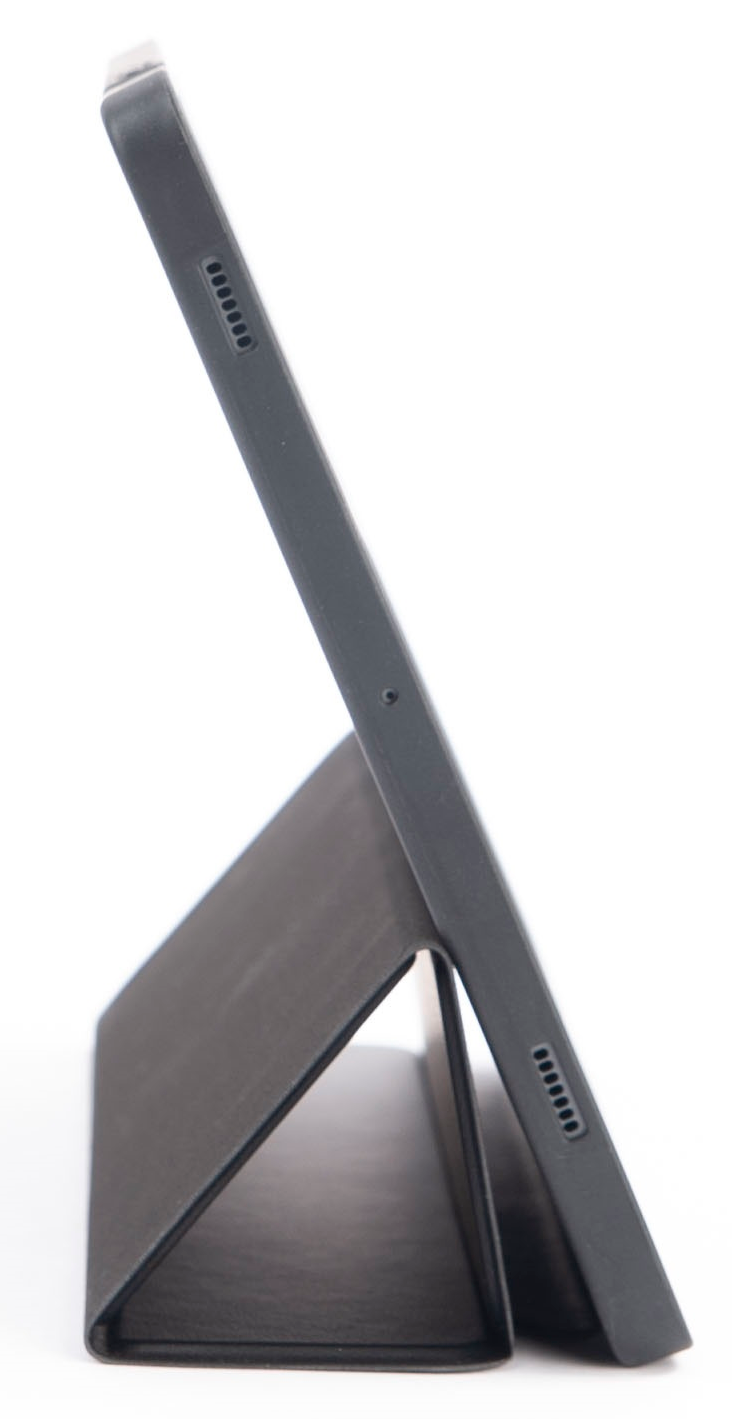 Fekete tablet állványban. Oldalnézet. Látható hangszórók és kamera. Fehér háttér.