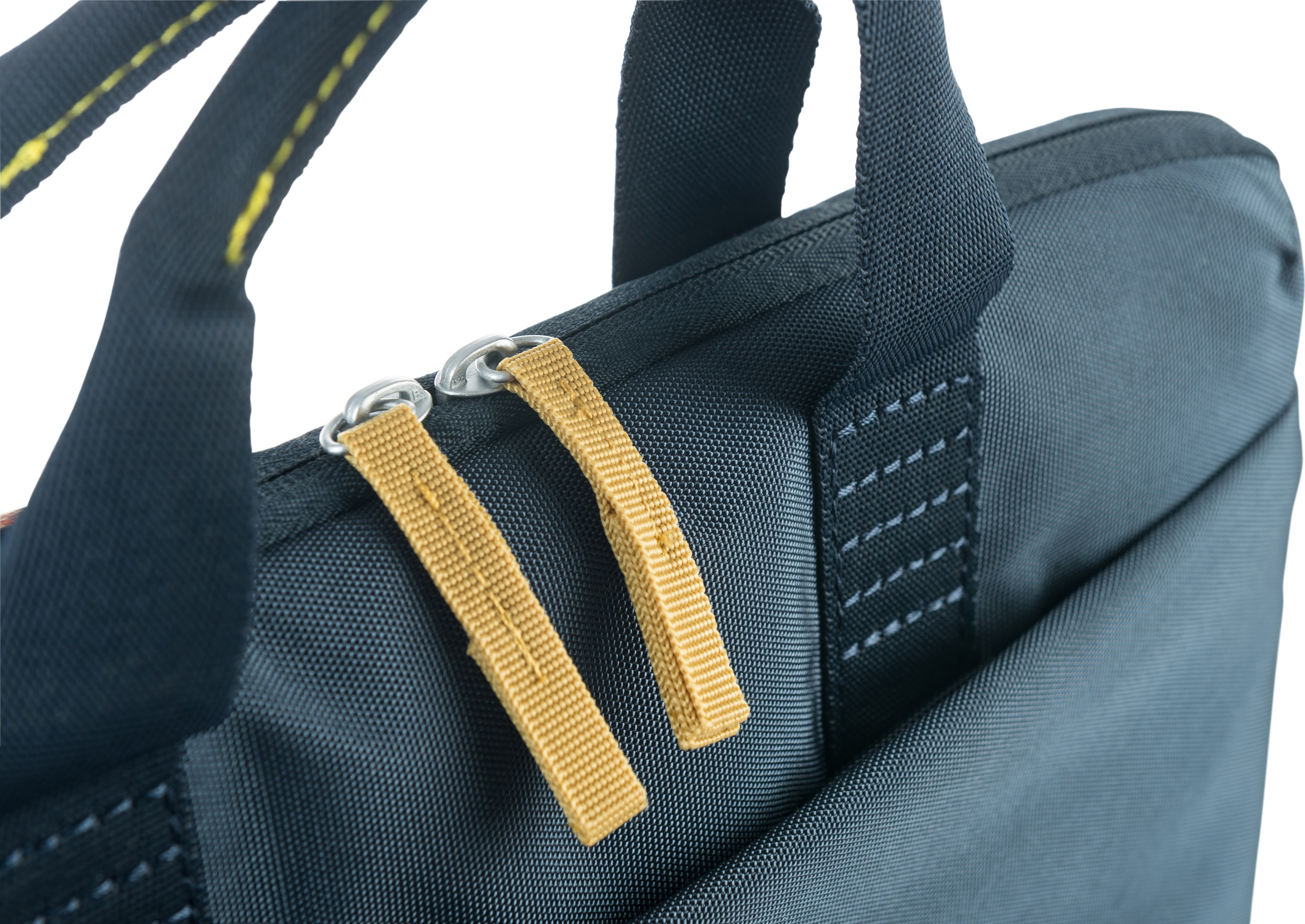 Nahaufnahme einer marineblauen Tasche mit gelben Reißverschlüssen und grauen Nähten.