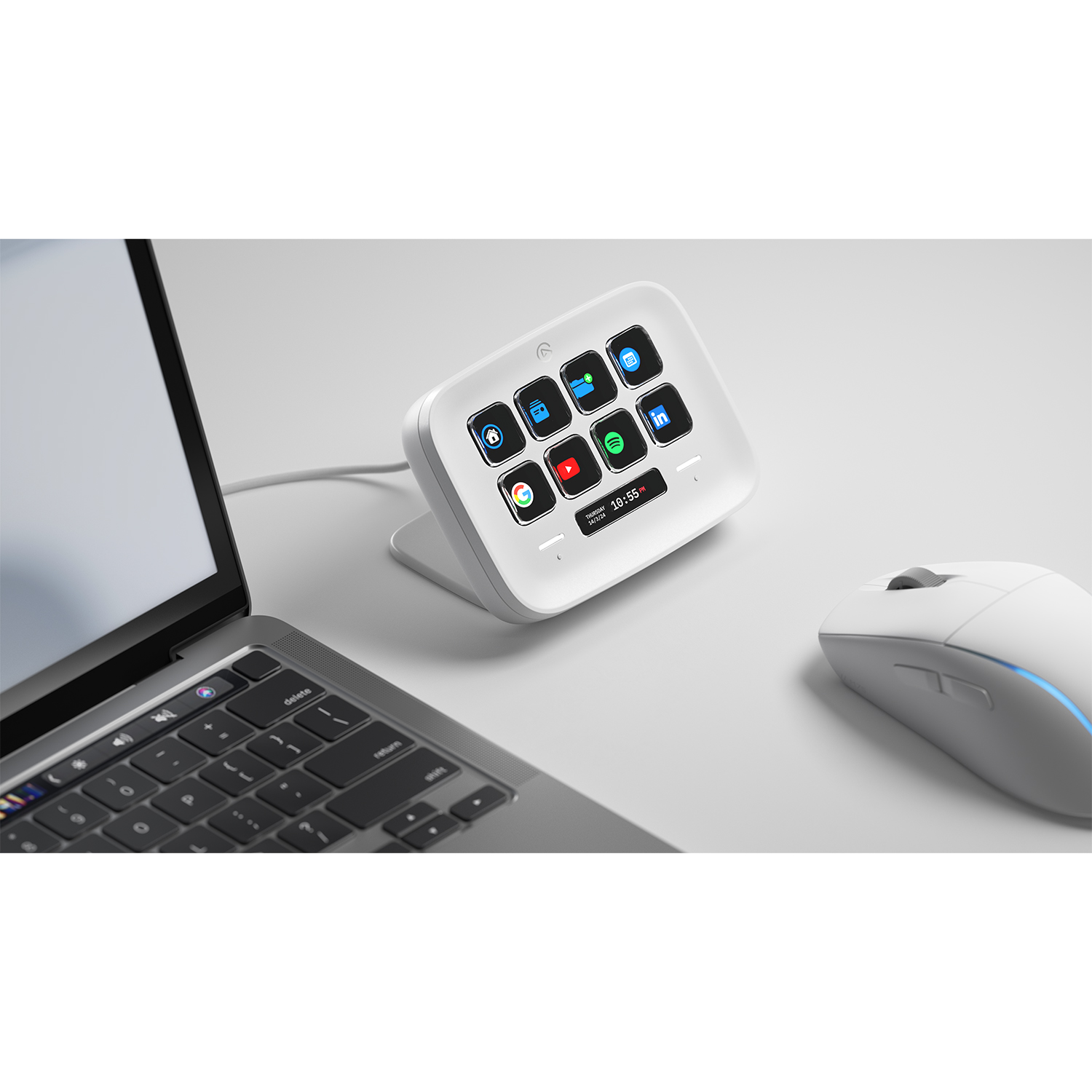 Un dispositivo Stream Deck bianco con icone, accanto a un laptop e un mouse bianco.