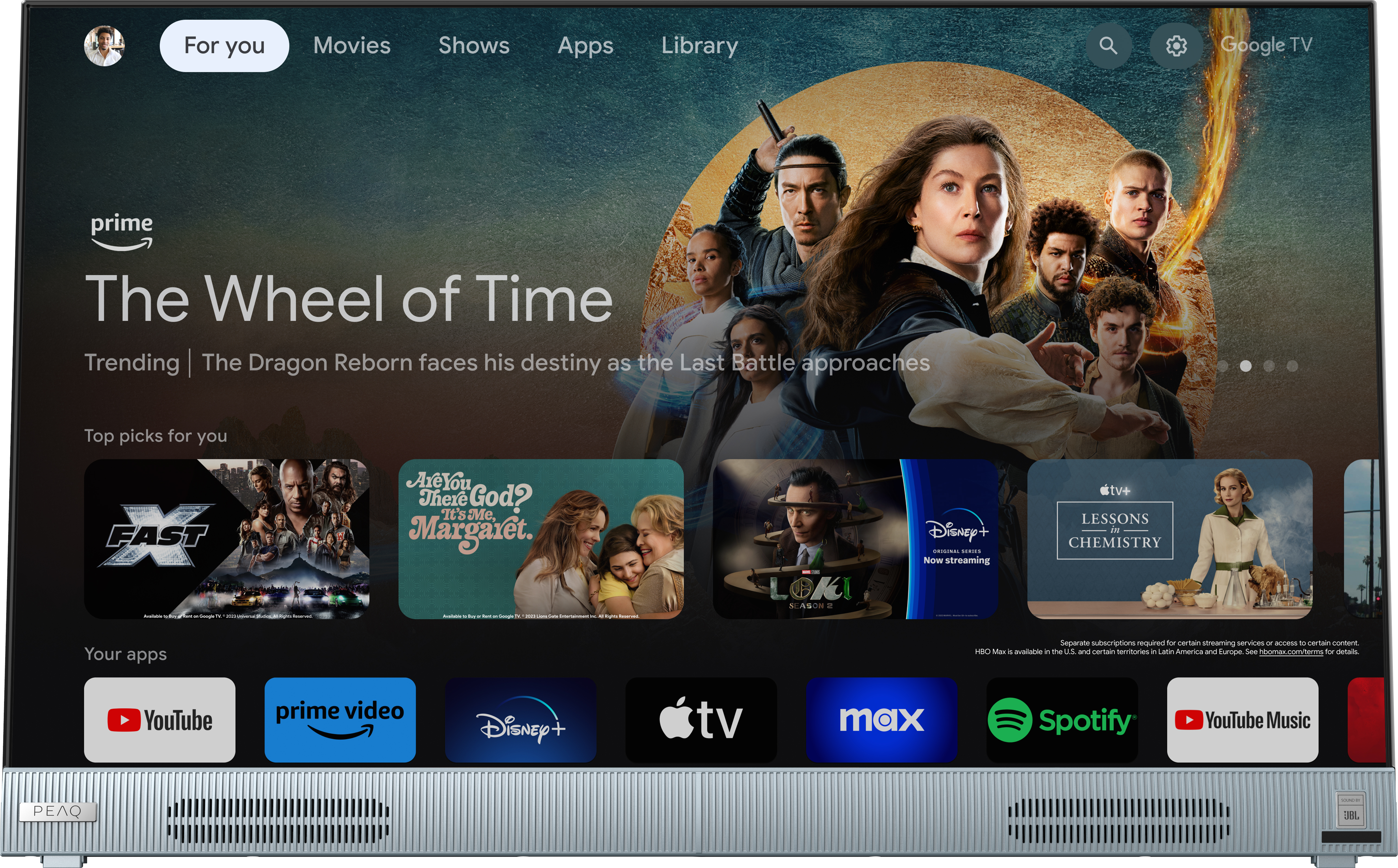 Ein Google TV-Bildschirm zeigt Apps und Sendungen an. Der Fernseher ist silberfarben und zeigt die Prime Video- und Netflix-Apps.