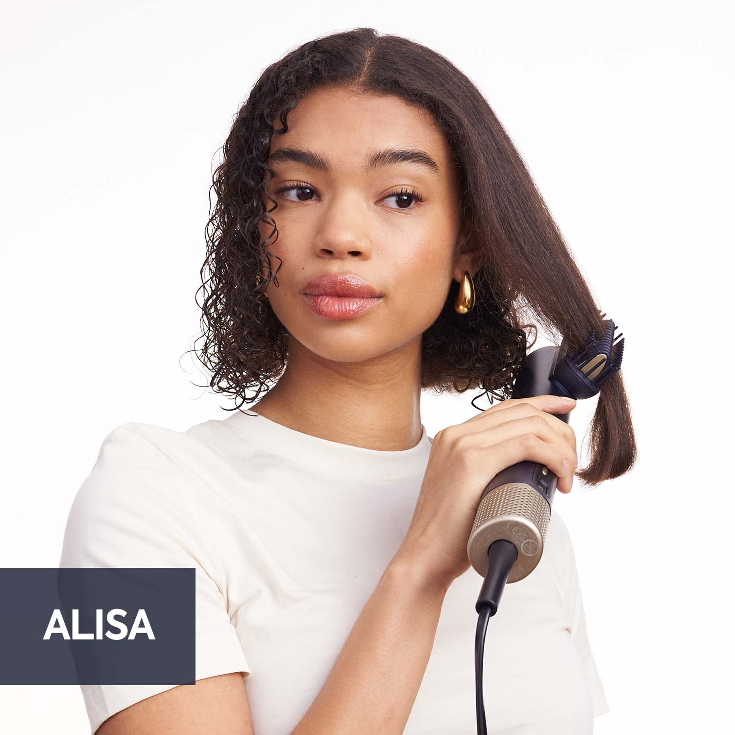 Una mujer llamada Alisa peinando su cabello con una herramienta.