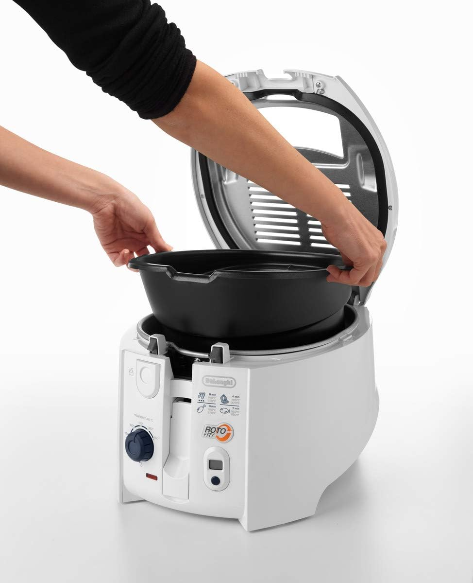 Mains plaçant un récipient noir dans une friteuse blanche.