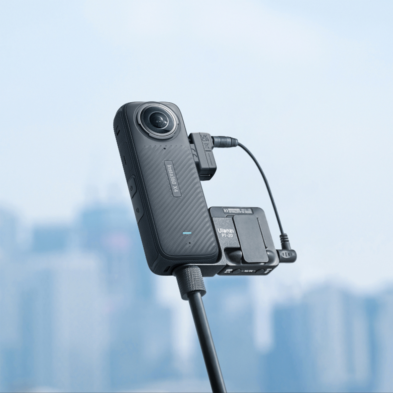 Una fotocamera 360 nera attaccata a un bastone per selfie nero.