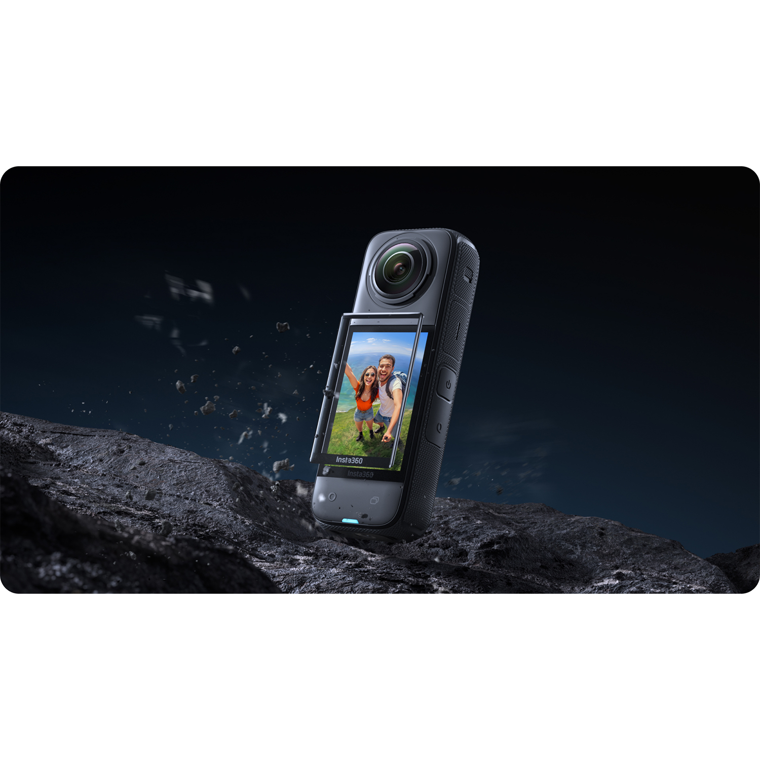 Una action camera con due persone sullo schermo. La fotocamera è su una superficie rocciosa. Sfondo scuro.