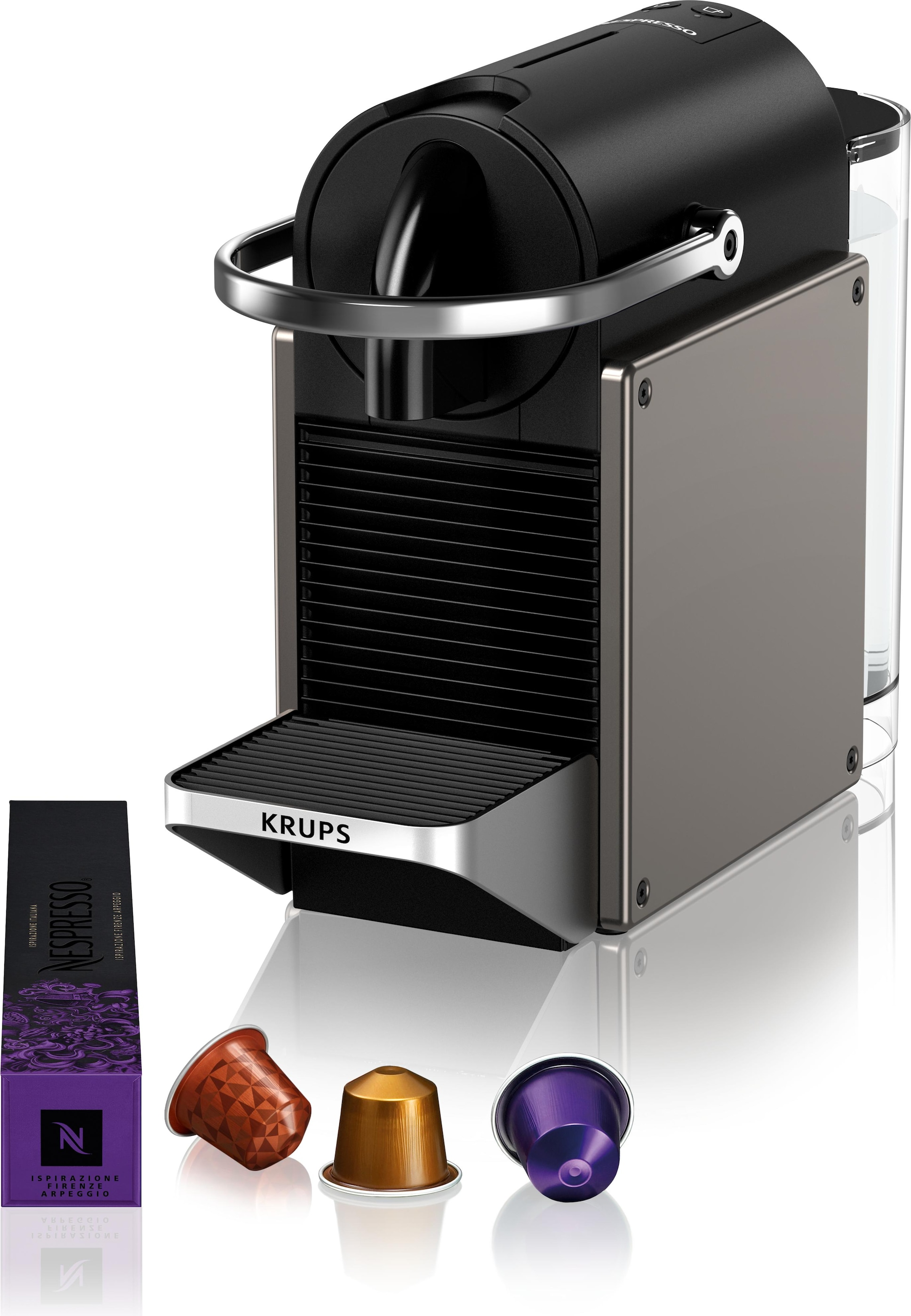 Fekete Krups Nespresso gép kávékapszulákkal és dobozzal, fehér felületen.