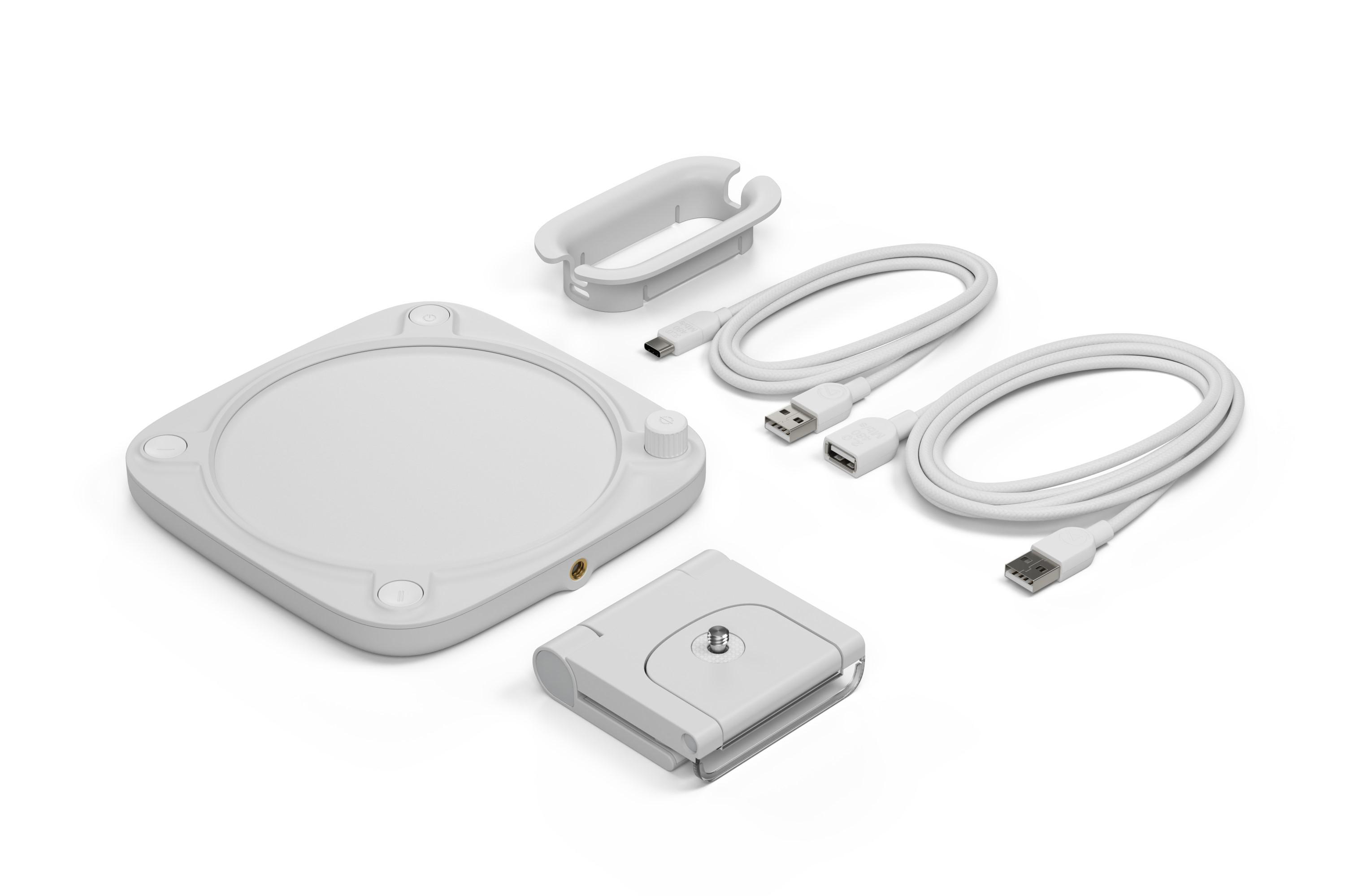 Weißes kreisförmiges Gerät mit Zubehör: Kabel, Halter und Halterung.