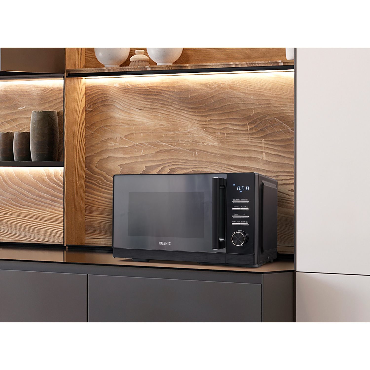 Un forno a microonde nero su un bancone in una cucina con mobili in legno e pareti bianche.