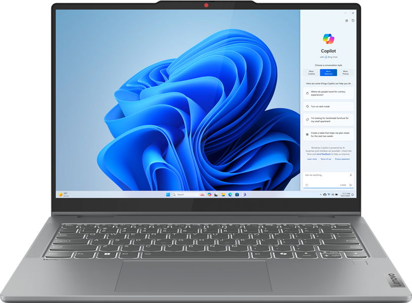 Laptop mit Windows-Oberfläche, die Copilot anzeigt. Der Laptop ist geöffnet und auf einem Tisch.