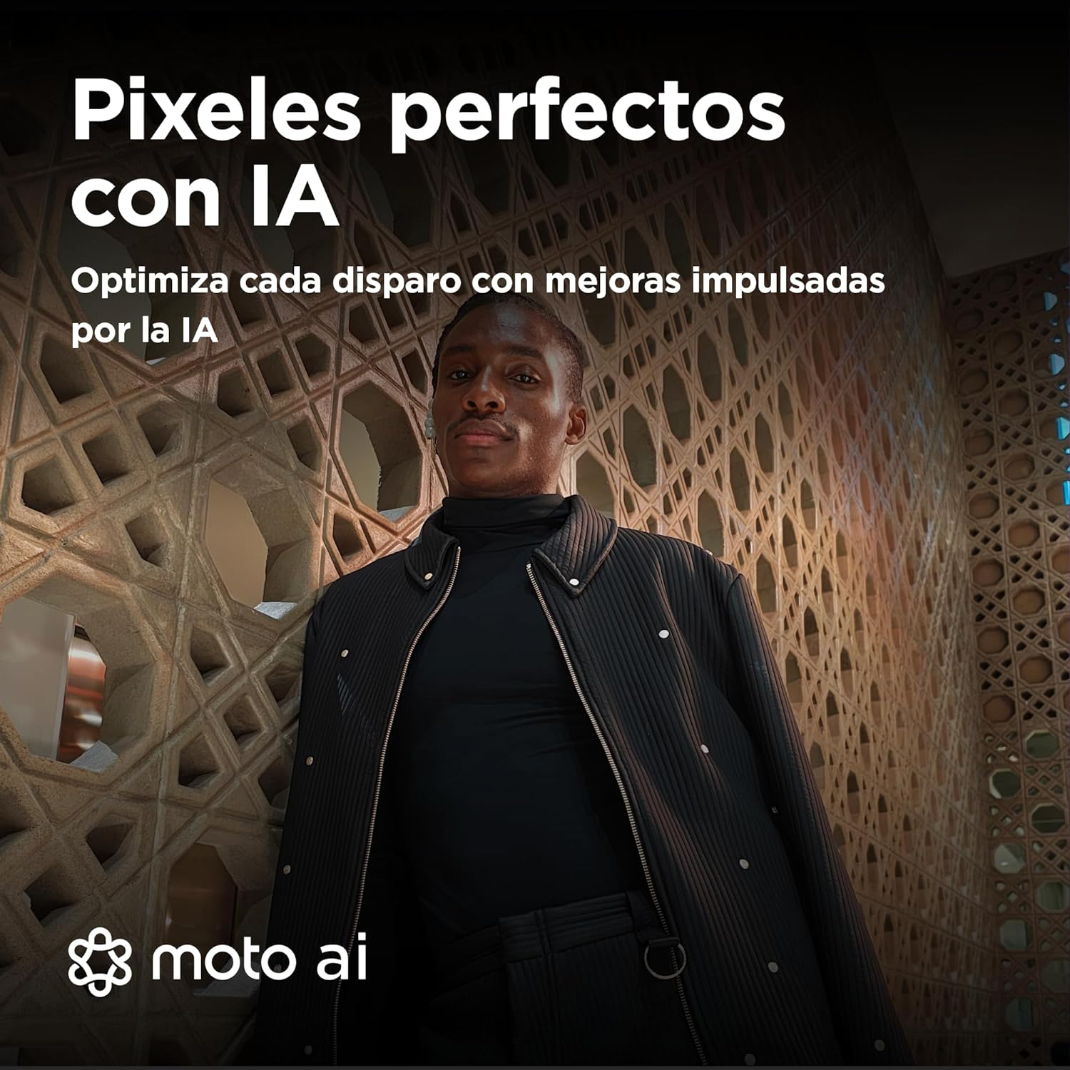 Hombre con cuello alto y chaqueta negros, apoyado en una pared estampada. Texto en español encima.