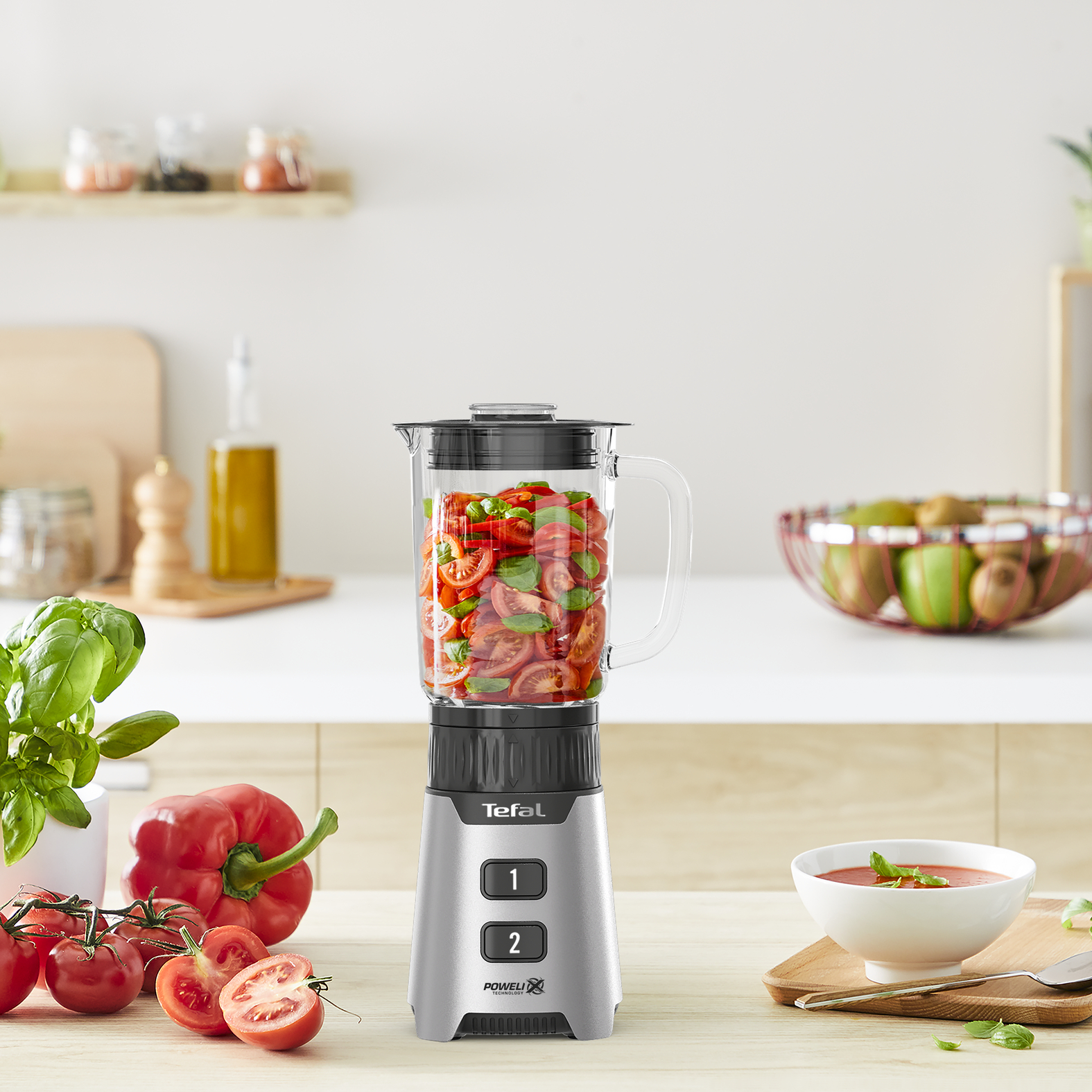 Tefal turmixgép, benne paradicsommal és bazsalikommal. Piros kaliforniai paprika, paradicsom és leves a pulton.