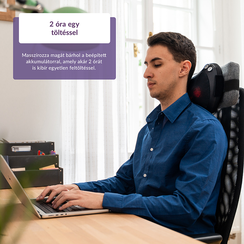 Egy férfi az asztalánál ül, laptopot használ, nyakmasszírozóval a székén.