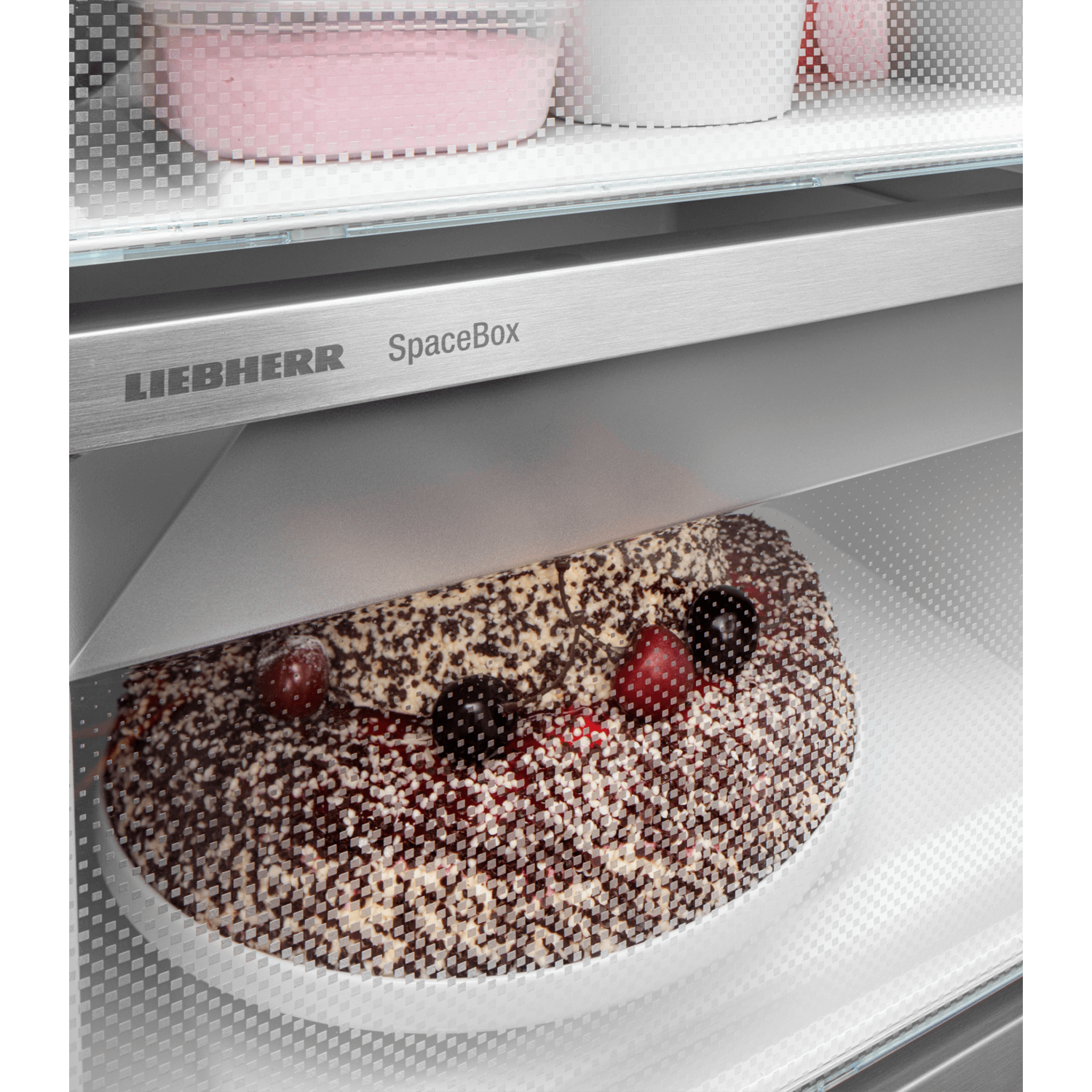 Refrigerator shelf with a frosted cake. The shelf is labelled 'LIEBHERR SpaceBox'.